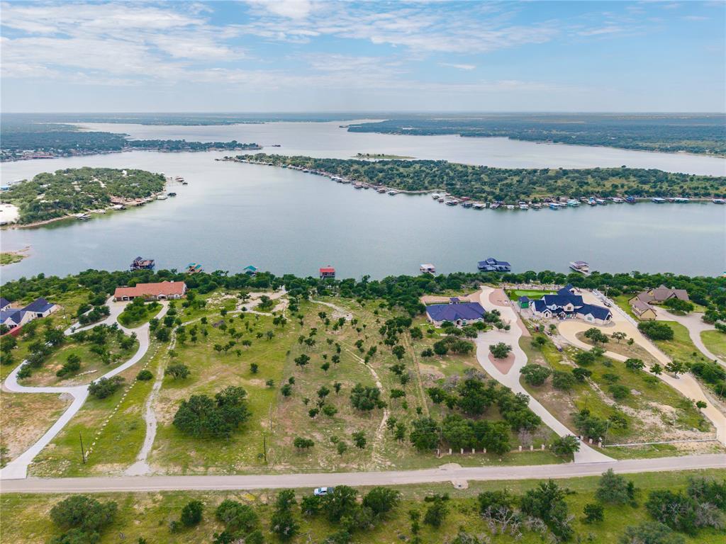 Stunning lakefront opportunity in the highly sought-after gated community of Deep Water Estates on Lake Brownwood! This exceptional 2.9-acre property offers some of the deepest water on the lake along with breathtaking views and an unbeatable location.
Enjoy the property now or build your dream home later—this lot is perfectly suited for both. A spacious patio and an impressive two-level dock make it easy to start enjoying lake life immediately. The dock features 3 slips, including 2 boat slips and a jet ski lift, ideal for entertaining and days on the water. Deep Water Estates is known for its large, beautifully landscaped lots, luxury homes, and peaceful, private setting—no crowded lots here. Take a drive through the community and experience the perfect blend of upscale living and relaxed, country-style lake life.Whether you’re ready to build or simply looking for a premier lakefront getaway, this property offers it all. Let's go!