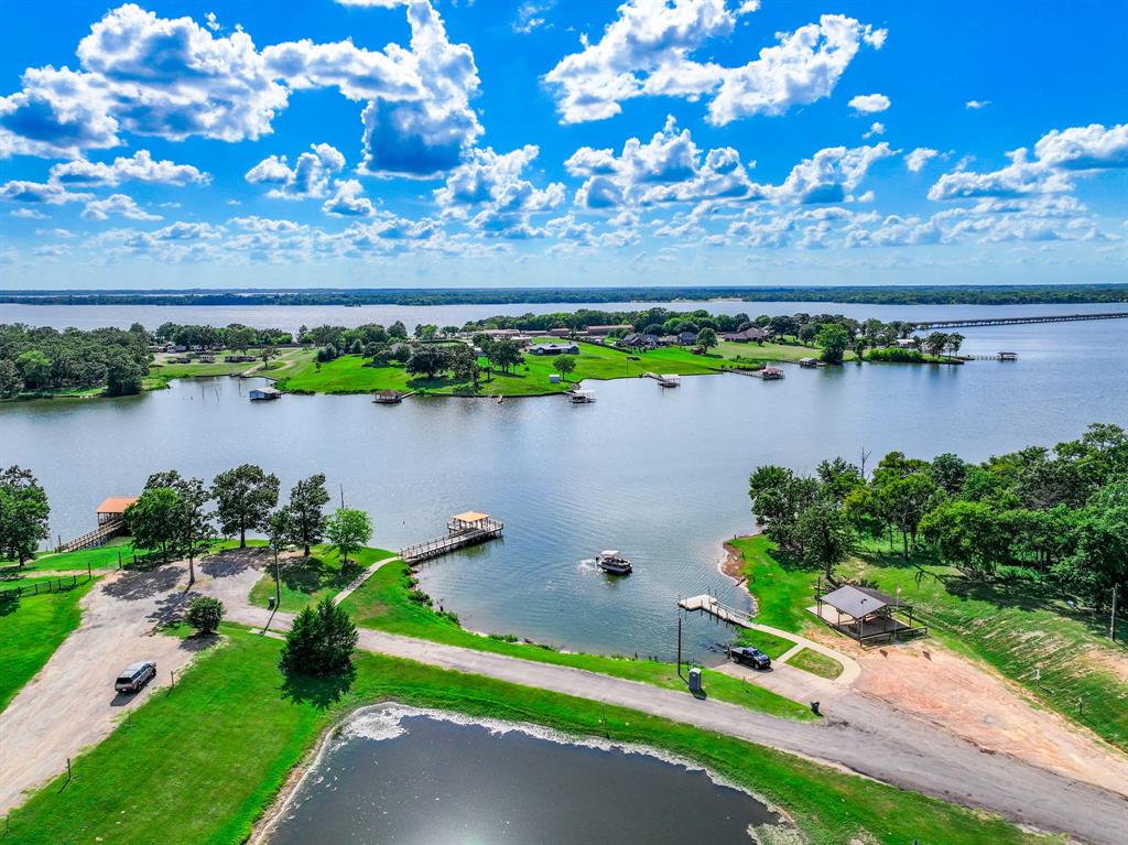 Turnkey furnished Lake Fork retreat in the gated community of Holiday Villages. This updated 3-bedroom, 2-bath home offers flexible living for full-time residents, weekend lake lovers, or investors seeking a move-in ready opportunity near one of Texas’ most legendary bass fishing lakes.
Offered fully furnished, the home provides immediate usability and added value for today’s buyer. The open-concept layout features a spacious living area and an eat-in kitchen with stainless steel appliances, creating an inviting space to relax or entertain after a day on the water. The primary suite is conveniently located on the main level, while two additional upstairs bedrooms offer space for guests, family, or a home office. Recent updates—including a newer roof, updated HVAC system, and modern interior finishes.
Step outside to a private backyard overlooking the community pond, offering a peaceful setting to enjoy quiet mornings, evening sunsets, or simply unwind. Residents of Holiday Villages enjoy access to community amenities including a covered fishing dock, private boat ramp, saltwater swimming pool, clubhouse, and playgrounds—making it easy to enjoy fishing, boating, and the relaxed Lake Fork lifestyle.
Whether you're searching for a primary residence, a weekend fishing getaway, or a furnished investment opportunity, this property presents an excellent value in one of Lake Fork’s most popular gated communities.