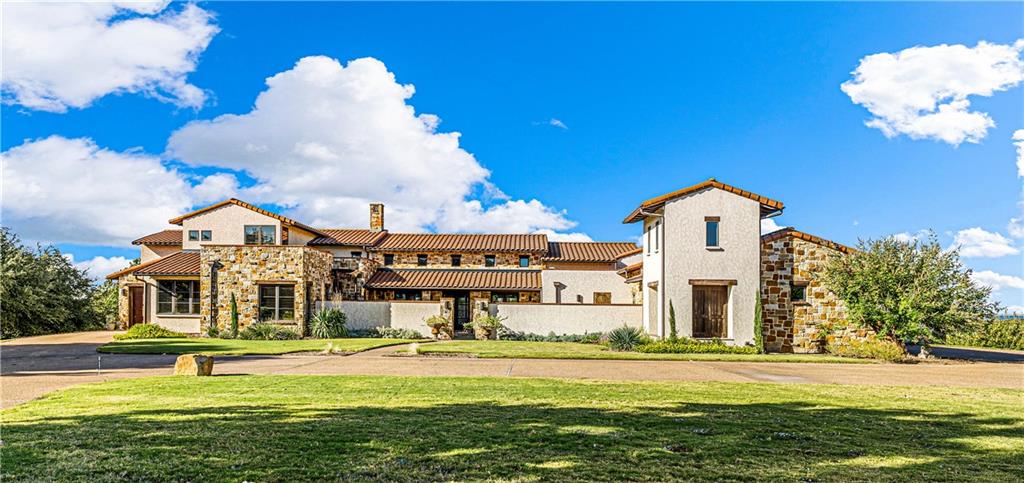 We’re elated to share this exceedingly rare, ultra-exclusive water front estate home which boasts a prominent, distinctive aesthetic perched atop rolling acreage; all conveniently and centrally located right in the Heart of Woodway’s Badger Ranch neighborhood!   ---   If you’ve ever dreamt of a home with waterfront access or a private, homestead acreage but just couldn’t manage the prerequisite, remote location or inconvenience of living outside of a suburban setting; …or, if you’re seeking a majestic setting, rolling topography, lake views, and an architecturally significant aesthetic full of intrigue and drama that’s distinctively different than the run of the mill, “cookie cutter” home; THIS HOME IS FOR YOU!   ---   Imagined and penned by acclaimed, award winning Central Texas architect Rick O’Donnel; the home’s expert fusion of “Tuscany meets Texas” was crafted in 2012 by local builder Sorrells and Gunn. Spanning 5,189 square feet of interior space, the four bedroom, five bathroom home is perfectly positioned upon four and half acres showcasing impressive views from every room, whether it be across one of the three bodies of water viewed from the property (Lake Waco, the Middle Bosque River, or the adjacent pond) or the magnificently manicured grounds; there is simply no other residence that’s as visually arresting anywhere in Central Texas.   ---   Once traversing the home’s formidable gate (secured and controlled by the home’s Control4 integrated system), a splendid, sun-filled courtyard greets visitors.  Across the meandering stone walkway, the home’s stately front door presents, ushering guests into a unique stone gathering room where the first hint of the home’s phenomenal views is on display.  Behind the foyer, the massive, central, formal living and dining rooms are flanked by an exquisite stone fireplace (one of four in the home) and serving area.  Bathed in abundant natural light from the dual, wall of windows and French doors; this room wonderfully acc
