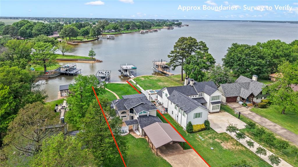 Positioned on a nearly half-acre (.483-acre) lot with 80’ of platted waterfront, this extensively updated lake home offers a like-new feel with an ideal blend of outdoor entertaining and indoor comfort.

The covered waterside patio creates an exceptional outdoor living space with granite countertops, bar seating, sink, built-in grill, mounted TV, and a spacious dining area—perfect for hosting and enjoying lake days with family and friends. The oversized backyard offers plenty of room for games or future additions like a firepit, pickleball court, or pool (with HOA approval).

A recently built composite boathouse features a boat slip, PWC lift, and spacious party deck—ready for summer entertaining and lakeside gatherings.

Inside, large picture windows bring in natural light and water views. The open-concept design features shiplap ceilings, recessed lighting, a wood-burning fireplace, and durable luxury vinyl plank flooring throughout. The dining area connects to a well-appointed beverage bar with ice maker and beverage refrigerator and flows into the beautifully remodeled kitchen with shaker-style cabinetry, quartz countertops, stainless appliances, and breakfast area.

The lower level includes an expansive bunkroom and a full bath with dual-sink vanity, tiled walk-in shower, and a laundry area with cabinetry and a granite folding counter.

The waterside primary suite offers a private balcony with cedar beams, modern cable railing, and exterior stair access to the patio. The spa-like en suite bath features a soaking tub, walk-in tile shower, and modern fixtures and finishes throughout.

Upstairs are two additional bedrooms connected by an updated Jack-and-Jill bath with stylish tilework and a walk-in shower.

Recent improvements include a newer roof, skylights, added insulation, and drainage updates. A dedicated water toy and tool shed provides convenient storage, while the long driveway and covered parking offer ample space for guests.