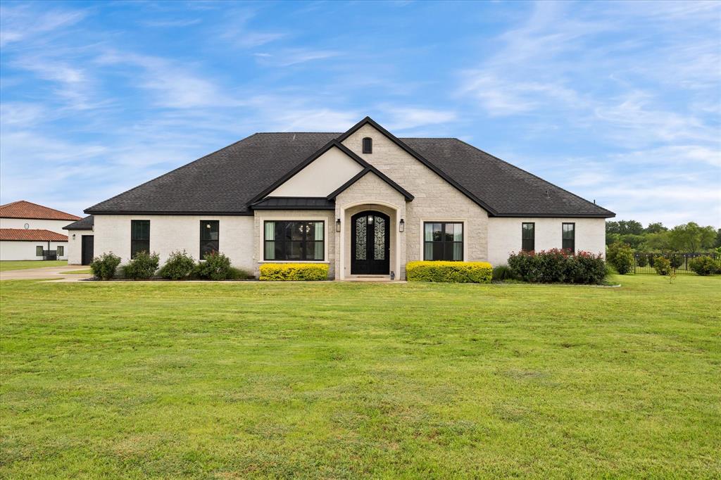 Beautiful one-story home on 2 gorgeous acres in High Point Ranch, built in 2020 with exceptional modern details and a split-bedroom floor plan ideal for family and guests. Outstanding curb appeal with an attached 2-car garage plus a detached garage-workshop with electricity, offering space for vehicles, hobbies, storage, or workspace needs. Impressive wrought iron entry doors make a grand first impression while offering durability and security. Inside, you are welcomed by an elegant dining room and a stunning coffered ceiling that adds timeless architectural character to the spacious living area. Large windows fill the home with natural light and overlook the sparkling pool, spa, and beautiful acreage beyond. The kitchen is truly a showpiece featuring a spacious quartzite island, decorative tile backsplash, gas cooktop, built-in stainless refrigerator, microwave-convection oven and separate electric oven. Other conveniences include built-in desk, wine rack, soft-close cabinetry, and an oversized pantry. All exterior doors are wrought iron, including the detached garage and outdoor half bath entry. The laundry room offers abundant storage, sink, under-cabinet lighting, and concealed pass-through storage hidden behind shelving. The private primary suite features a designer paneled accent wall and peaceful views of the pool and outdoor living area. The luxurious ensuite bath includes double vanities, separate makeup vanity, large shower, and two spacious closets with shelving and window. Secondary bedrooms are generously sized with ample closet space and convenient access to an impressive full bath. The outdoor living area is designed for entertaining with a stunning pool and spa, exquisite outdoor kitchen, expansive patio space and breathtaking views of the land and wide-open Rockwall County skies. High Point Ranch residents enjoy a community park, walking trail, and fishing pond. A rare blend of luxury, comfort, and peaceful country living! A MUST SEE!!!
