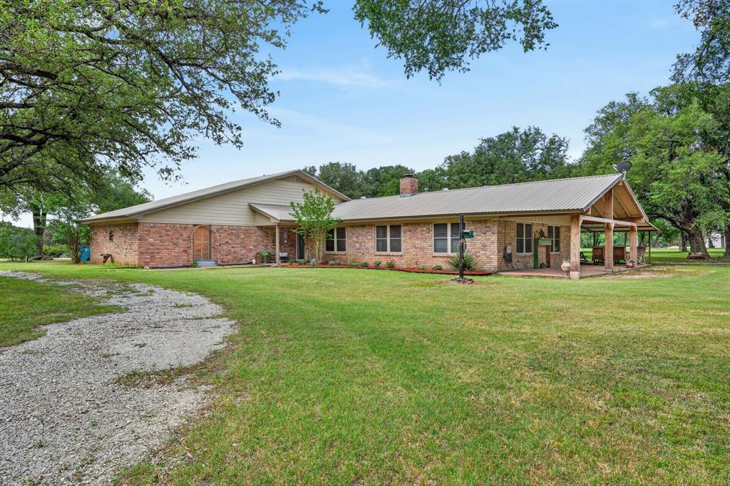 Nestled on 6.554 beautiful acres in a highly desirable area off FM 708, this updated 3-bedroom, 2-bath home offers the perfect blend of comfort, charm, and country living. Inside you'll find three spacious living areas including a welcoming living room, cozy den, and a rustic family room perfect for gathering and entertaining. The updated kitchen, remodeled less than two years ago, features a double electric oven and opens to a small breakfast nook.

The spacious primary bedrooms offers plantation shutters and a relaxing retreat at the end of the day. The den boasts vaulted ceilings, a wood-burning fireplace, and plenty of room for family and guests. Step outside to enjoy large covered porch area on two sides of the home, ideal for outdoor entertaining, wildlife viewing, or simply taking in the peaceful surroundings.

The property is beautifully landscaped with mature trees and grass surrounding the home, creating a private and picturesque setting. A sell-equipped shop with electricity, insulation, and a new garage door adds every more functionality to this exceptional property.