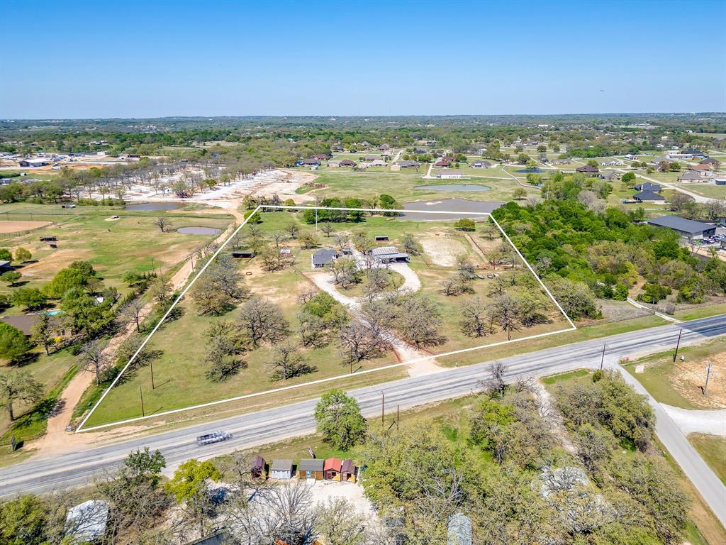 Premier 11.56-acre opportunity with exceptional visibility and high-traffic frontage on Ranger Highway (Spur 312), just minutes from Interstate 20 and Downtown Weatherford. Positioned in one of Weatherford’s fastest-growing corridors, this versatile property offers endless potential for residential, commercial, mixed-use, investment, or development opportunities.
Extensive road frontage provides outstanding visibility and accessibility, making it ideal for a private estate, ranchette development, business location, office conversion, industrial use, retail, or future redevelopment.
The property includes an approximately 1,800 SF structure that could easily be transformed into a residence, office, showroom, or business space, along with a large shop and multiple storage areas to support a variety of uses. Expansive open acreage allows ample room for additional homesites, commercial expansion, recreational amenities, livestock, or future development.
Whether you’re looking to create a private homestead, establish a business presence, invest in land, or develop a high-impact project, this property delivers unmatched flexibility, location, and long-term upside.
Survey and conceptual renderings for residential and commercial possibilities available. Contact agent for additional details.