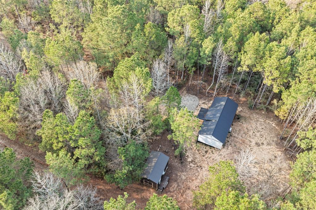 Cannon Creek Hideout is tucked away in northeast Rusk County, this 18.39-acre property offers a quiet East Texas retreat surrounded by timber, wildlife, and the natural beauty of the countryside. 200 feet of frontage along County Road 2136 provides easy access to a winding driveway that leads through a canopy of trees to a cozy 720 square foot cabin that provides the comforts of home while maintaining the feel of a secluded getaway. The cabin features a two-bedroom 1 bath with ample living room and kitchen space. The land features a healthy mix of cedar, oak, and pine, blended with pockets of native grasses that create a diverse landscape and excellent habitat for wildlife. A live creek winds its way through the property, adding both scenic appeal and a reliable water source that helps sustain the abundant game known to frequent the area. Wildlife is plentiful, with whitetail deer, feral hogs, and small game regularly seen throughout the property. For those interested in hunting, a stand and feeder are already in place near the back of the tract, offering a ready-made setup for enjoying the land from day one. Located within the highly sought after Tatum ISD, this property combines privacy, natural beauty, and recreational opportunity. Whether you’re looking for a weekend escape, a hunting camp, or a small East Texas acreage to call your own, this tract offers a peaceful setting just far enough off the beaten path. Schedule your showing today and inquire about the rental potential for this property!
