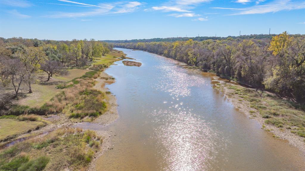 Rarely does a Brazos Riverfront home in Pecan Plantation become available at this price point. Recently repriced to $479,900, this exceptional waterfront property offers breathtaking river views, abundant wildlife, and a peaceful cul-de-sac setting in one of Granbury's most sought-after gated  golf communities. With over 2,600 square feet, this spacious two-story home is designed to maximize the beauty of its surroundings. Large windows fill the home with natural light while showcasing stunning views of the Brazos River from every room in the home. The inviting living area features a cozy fireplace, built-in bookshelves, & generous storage, creating a comfortable space for everyday living and entertaining. The updated kitchen is equipped with granite countertops, stainless steel appliances, and a GE Profile double-oven range, making it ideal for hosting family gatherings and holiday celebrations. The spacious primary suite offers beautiful river views, dual vanities, & an updated walk-in shower, creating a relaxing private retreat. A flexible floor plan provides comfortable space for guests, hobbies, or a home office.  Step outside to multiple balconies and outdoor living areas overlooking the river where you can enjoy morning coffee, evening sunsets, and the sights of deer and native wildlife year-round. Located on the golf cart path with convenient access to the clubhouse, this home offers the lifestyle buyers love about Pecan Plantation. Residents enjoy championship golf, two swimming pools, tennis and pickleball courts, parks, walking trails, recreation facilities, a community garden, marina access, private airstrip, and the convenience of the on-site Village featuring grocery shopping, restaurants, a coffee shop, pharmacy, medical clinic, bank, and more. Whether you're seeking a full-time residence, retirement retreat, or weekend escape, this rare riverfront opportunity offers privacy, views, and an unmatched lifestyle at an exceptional value.  Welcome Home!