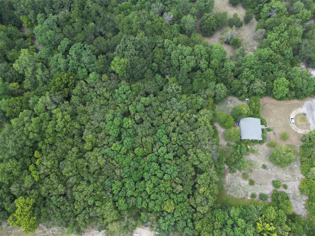 Great location with a heavily treed lot with a total 7.16 acres offering plenty of privacy. The house that is currently on the property has many options for the people with a good vision or like a project. We are putting the VALUE IN THE LAND not the home. The land is very versatile which can be used as a primary residence or can be rezoned for commercial use as some of the surrounding properties are currently zoned commercial. The creek running through the lot offers beautiful views allowing you to watch deer, birds and other animals in the area. This property offers co op water which is a rare find in this area. With the right vision, this land offers endless opportunities. You are out in the country but can be back in town within a matter of minutes giving you the flexibility for the country and city life. This is a two parcel property and both combined make 7.16 acres. They are being sold together and will not split. Back of the property is in a flood zone according to the FEMA map.