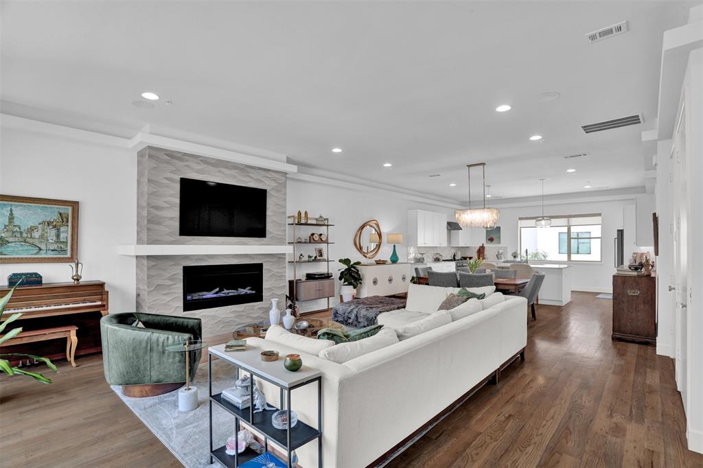 Welcome to Villas on Hutton #10, one of only 32 exclusive residences in this rare luxury townhome community tucked in the heart of Farmers Branch. This stunning home offers four levels of thoughtfully curated custom finishes that cannot be replicated in new construction at this price. The main living level impresses immediately with wide-plank hardwood floors, 8-ft solid-core doors throughout, a dramatic sculptural tile fireplace, and an open-concept layout that flows seamlessly into the chef's kitchen. Here you'll find marble countertops, an oversized island with seating, a commercial-grade 6-burner gas range with electric oven, KitchenAid appliances, custom cabinetry, and a walk-in pantry with a wine fridge and built-in bar. A stylish powder bath with marble countertops finishes the second floor. The private elevator serves all four levels, including a first-floor guest suite with en-suite bath, a main-level laundry room, and a luxurious primary suite featuring a tray ceiling, barn door entry, spa-inspired bath with freestanding soaking tub, oversized frameless glass shower and walk-in closet. A second en-suite bedroom and a flexible office or third bedroom with its own bath round out the upper floors. The home enjoys one of the largest private yards in the community, with a peaceful interior position that does not face an exterior street. The crown jewel is the rooftop level, where an outdoor kitchen with built-in Coyote grill, refrigerator, and sink anchors one end, while a tiled outdoor fireplace, pergola-covered dining area, sun loungers, and a private hot tub create a true outdoor living experience. Community amenities include a pool & planned dog park. Minutes from DFW International Airport, Downtown Dallas and major corridors including I-35, LBJ 635, and President George Bush Turnpike. The Mercer Crossing development puts world-class shopping & dining right at your doorstep. This is lock-and-leave luxury at its absolute finest.