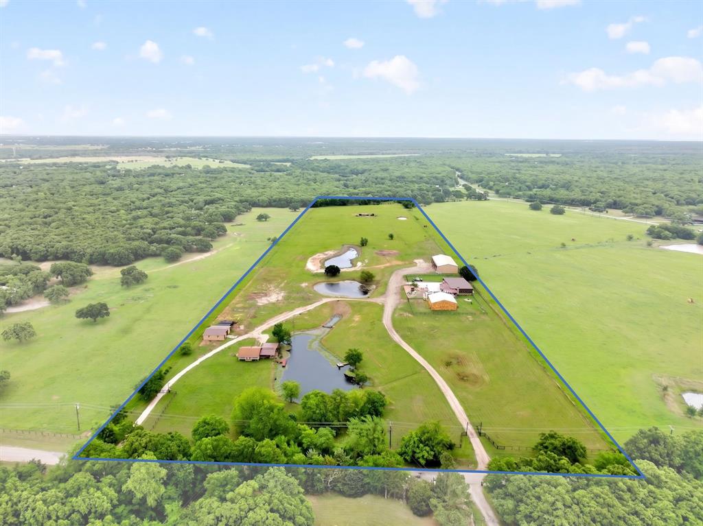 Poetry Estate situated on 20+ acres. Endless potential and income opportunities with multiple residences, shops and more! An entertainer or entrepreneur's dream! Main home features reclaimed wood, stone, and tin for a foundational lodge feel and the turquoise accents bring a distinctive Southwestern touch. Double arched door with glass panels that are aesthetically pleasing while enhancing the functionality and access. Open floor plan with captivating stone wall and fireplace. Beautiful kitchen compliments the rustic design with luxury quartz countertops and hammered copper sink. ONE OF A KIND property with undeniable character and charm. 4 BR with two primary suites featuring ensuite baths and dual vanities. The main suite is a retreat with a generous walk-in closet, morning bar, mosaic pedestal soaking tub and spa-like shower system for ultimate comfort.

Attached Gentlemen's Cigar Lounge designed with timeless sophistication, luxury and comfort. Walk in humidor, a focal point with large picture frame windows. Professionally ventilated with dimmable lighting. Bar with commercial set up. Flexible space for storage or pet room connected to dog run, half bath and much more!

Unique Silo Bar overlooking pool. Outdoor kitchen and incredible big screen to enjoy all the big events pool side which is the best way in Texas. Saloon with 3 full view bay doors, seamlessly bridging the interior with the exterior. Perfect for the car collector or enthusiast. All spaces ideal for entertaining. Ultimate hospitality and functionality. Saloon includes 2 BR, one with ensuite bath, 2 half baths, as well as fitness center with mirror wall, thick rubber flooring and more!

Separate shop with 2BR, 2BA apartment. 

Secondary Residence perfect for homestead or residential income property. 3BR, 2 BA with covered patio overlooking pond and private dock to enjoy fishing, ducks and Texas views. Large shop with additional storage and space for chickens, etc. See property feature sheet!