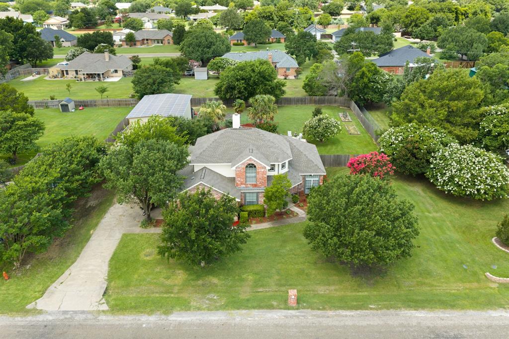 This property truly has it all! Located in the county just outside of Waxahachie, you’ll enjoy no HOA and no city taxes while still being just minutes from town. This well-maintained home offers 4 bedrooms, 2.5 bathrooms, a dedicated office, a formal dining room, and a breakfast area. The garage has been converted into an additional bedroom, and the office could easily serve as a 5th bedroom, giving you plenty of flexibility for guests, a growing family, or working from home. The primary suite features a beautifully remodeled walk-in shower, and the home has been refreshed with fresh interior paint. One of the biggest benefits is the fully paid-off solar panel system. Combined with the home’s all-electric setup, you’ll enjoy outstanding energy efficiency and lower utility costs. Step outside and enjoy your own backyard retreat with a resort-style inground pool, beautiful landscaping, and a large, covered patio that’s perfect for relaxing or entertaining. If you need extra space for projects, vehicles, or storage, you’ll love the workshop with electricity, complete with two automotive lifts. It’s a rare feature that’s perfect for car enthusiasts, hobbyists, or anyone needing a serious workspace. From the energy savings to the incredible outdoor living and versatile floor plan, this home has been exceptionally maintained and is ready for its next owners to enjoy.