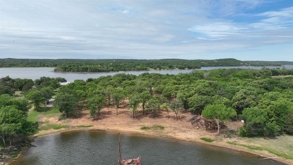 Discover the perfect opportunity to build your dream home, weekend retreat, or investment property on this beautiful 2.25-acre waterfront tract on Amon G Carter Lake.  Located on Selma Rd which is near the north side of Amon G. Carter Lake, this property offers the ideal combination of peaceful country living and convenient access to nearby amenities.

The biggest appeal of this lot is its Waterfront location—water is right at the front of the property, with a walk-in beach-style entrance. Whether you’re looking for an easy place to relax, swim, or enjoy time on the lake, the shoreline is immediately accessible. The tract also features beautiful mature trees for privacy and natural beauty, and the public boat ramp is located nearby for quick, convenient launching.

Conveniently situated just 6 miles from Highway 287, 7 miles from historic downtown Bowie, 45 miles from Wichita Falls, 60 miles from Fort Worth, and 75 miles from DFW Airport, you’ll enjoy a quiet rural setting without sacrificing accessibility.

Surrounded by the natural beauty of North Texas, the property offers scenic surroundings, abundant wildlife, and access to some of the area’s best outdoor recreation. Amon G. Carter Lake is known for excellent fishing, including largemouth bass, catfish, and crappie. Nearby public boat ramp access and Selma Park campground make it easy to enjoy everything the lake has to offer.

Additional features include paved road frontage, electricity available at the road, and an existing survey. With no MUD or PID, this property provides flexibility and value for future owners.

Whether you’re looking to build now or invest for the future, this 2.25-acre waterfront tract offers a rare opportunity to own land in a desirable lake-area location.