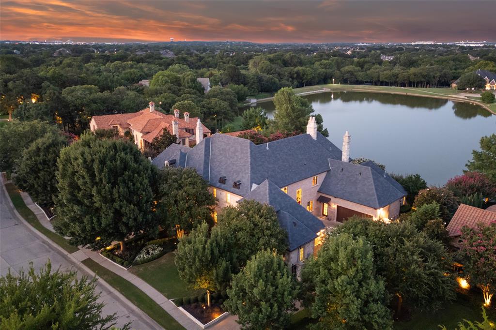 Absolutely stunning! From the moment you enter this fabulous estate the breathtaking water views will leave you awe-struck! Enjoy the lush grounds & stunning view of the infinity edge pool & fountain with cascading waterfalls that seamlessly blend with the backdrop of the lake.  Filled with the finest appointments including extensive hardwood & stone flooring, completely upgraded Control 4 Smart Home Automation, 6 fireplaces, exquisite millwork, high ceilings with lighted domes,  luxurious master suite with a coffee bar and a spa-like bath retreat with a sauna! Updates include stunning marble fireplace w backdrop lighting, designer wallpapers & carpeting, Pierce fine hardware, dining chandelier & entry sconces from NY Design House plus more! The backyard oasis offers an outdoor living area with fireplace, Lynx grill, an outdoor firepit, mosquito nix system & automated landscaped lighting. Private exercise room off upstairs balcony. A fine estate in the premier gated Tanglewood Estates!