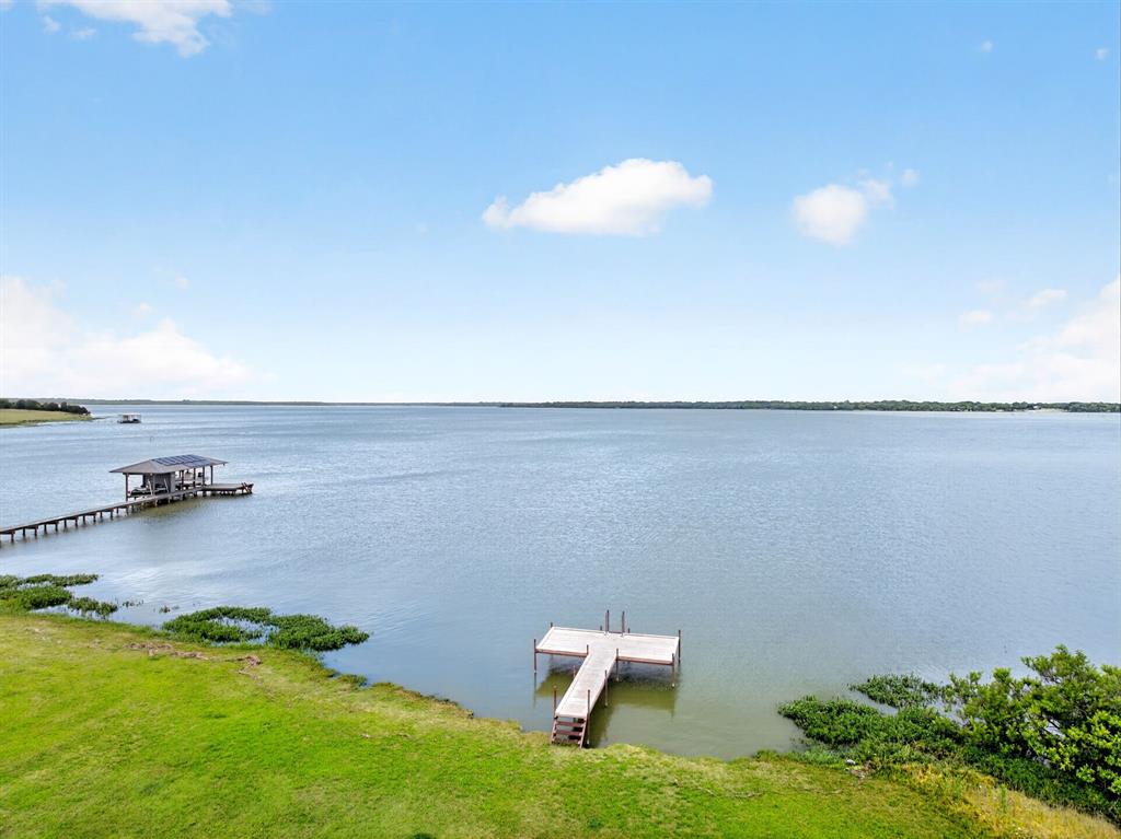 Experience lakefront living at its finest with this beautifully updated 3-bedroom, 2-bath home located on the open water of Lake Tawakoni. Situated on approximately .18 deeded acres plus an additional .50 acre Sabine River Authority leaseback, this property offers breathtaking views, incredible outdoor living, and endless recreational opportunities. Inside, you’ll love the spacious open floor plan featuring three generously sized bedrooms, updated finishes, luxury vinyl plank and wood flooring, and a beautifully remodeled kitchen complete with granite countertops and stainless steel appliances. Large windows invite natural light while showcasing stunning lake views throughout the home. Step outside to enjoy the expansive 50’ x 13’ covered outdoor entertaining deck overlooking the lake, the perfect setting for morning coffee, sunset gatherings, or weekend entertaining.. Approximately 100 feet of shoreline on the open lake with new dock, making it ideal for boating, fishing, and waterfront fun. The home has central propane heat, city water, and a voluntary HOA. Whether you’re looking for a full-time residence, weekend getaway, or income-producing Airbnb opportunity, this lake house checks every box. Conveniently located on Lake Tawakoni, this property offers the perfect blend of relaxation, recreation, and investment potential.