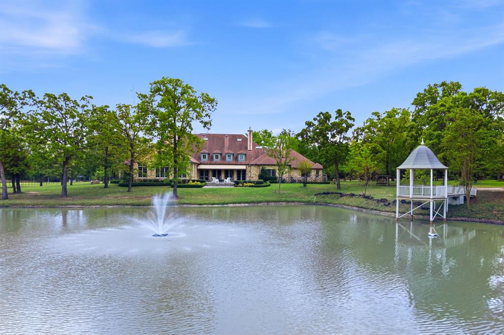 Exquisite French Country stone estate set on 92 breathtaking rolling acres in East Texas, blending timeless ranch heritage with refined architectural detail just one hour from Dallas. Tucked behind a private drive and surrounded by mature trees, open pastureland, berry vines, three stocked ponds, and a gently winding creek, the property evokes quiet luxury reminiscent of a classic countryside retreat.
The main residence spans 8,355 sqft & is rich in character, showcasing curved archways, exposed brick accents, hand-scraped hardwood floors, soaring ceilings, & 6 wood-burning fireplaces that create warmth throughout. Designed for both everyday living & entertaining, the home offers multiple living areas, a chef’s kitchen with butler’s pantry, & architectural details that feel both elevated & welcoming.
The expansive primary suite offers a private retreat with a spa-inspired bath featuring a walk-in shower, soaking tub, dual vanities, generous his-and-her closets, & a wet bar. The current owner expanded the home to include 2 additional bedrooms with en-suite baths & a spacious den with bar area, ideal for multigenerational living or extended guest stays.
Designed for gathering, the property includes three charming guest homes offering comfortable accommodations for family and visitors. Outdoor living is equally inviting, with a picturesque stone patio & gazebo overlooking a tranquil pond with lighted fountain — perfect for slow mornings & sunset evenings. The acreage offers a recreational escape with wooded trails, varied topography, & abundant wildlife. Enjoy fishing, ATV riding, hiking, hunting, or simply embracing the privacy and beauty of the land. Additional improvements include a commercial-grade greenhouse, workshop, gym, helipad, well system, & infrastructure supporting agricultural use. Horses permitted.
A timeless legacy property offering heritage, craftsmanship, and space to gather for generations to come.
Visit easttxestate online for more information.