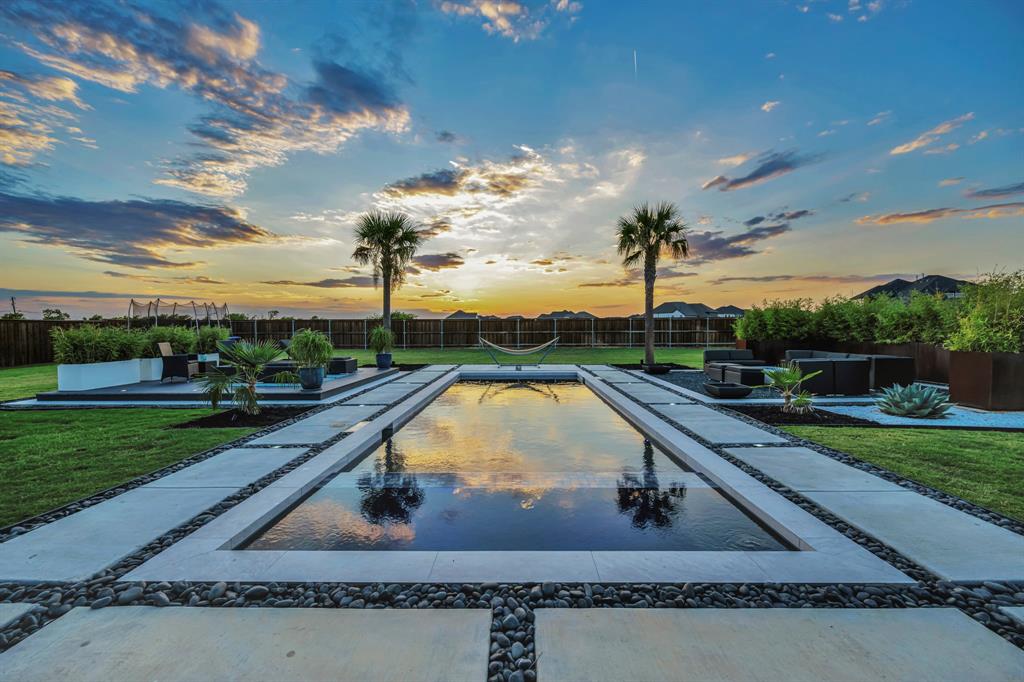 This 2023 completed home captures the essence of laid-back luxury and effortless entertaining.

From the moment you step inside, the warmth and flow of this 3,924 sq ft retreat draw you in. Wide open living spaces and thoughtful design make it just as easy to host a lively gathering as it is to unwind in peace.

At the heart of the home, the chef’s kitchen invites connection with its oversized island, professional 6-burner gas range, and custom cabinetry that opens seamlessly to the living and dining areas. Large sliding glass doors extend your living space outdoors, creating the perfect indoor–outdoor experience for dining, entertaining, or simply enjoying the evening breeze.

Upstairs, two spacious bedrooms each offer private en-suite baths, providing comfort and flexibility for guests or family. The media room with built-in audio-visual systems makes movie nights and weekends feel like an event.

Outside, the resort-style backyard sets the scene for year-round enjoyment with a sparkling pool and spa combo, fire-pit lounge, deck, and extended covered patio—all framed by open skies and wide Texas sunsets. And with no neighbors behind… for-ev-er, your privacy and peace are here to stay.

Set on an .5 acre lot with a three-car side-split garage, this home combines quality, style, and heart in a way that’s hard to find. Built for gathering, relaxing, and celebrating the good life—every single day.