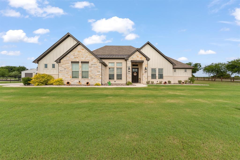 Welcome to country luxury at its finest! Nestled on a spacious homesite in the highly sought-after Bella Terra community, this stunning custom-built home offers the perfect blend of modern elegance, comfort, and Texas charm.
Step inside to an impressive open-concept design featuring soaring ceilings with beautiful exposed wood beams, a floor-to-ceiling stone fireplace, designer lighting, and expansive windows that fill the home with natural light while showcasing picturesque views of the surrounding countryside. The spacious living area flows seamlessly into the chef-inspired kitchen, complete with custom cabinetry, granite countertops, stainless steel appliances, decorative tile backsplash, oversized island with seating, and abundant storage—perfect for entertaining family and friends.
The private primary suite is a true retreat featuring a spa-like ensuite bath with dual vanities, a freestanding soaking tub, oversized walk-in shower, and generous walk-in closet. Spacious secondary bedrooms provide comfort and privacy for family or guests, while a versatile bonus room offers endless possibilities as a home office, gym, media room, or additional living space.
Outside, enjoy peaceful Texas sunsets from the covered patio overlooking the beautiful backyard .  A detached shop provides additional space for hobbies, storage, equipment, or workshop needs, making this property ideal for those seeking both functionality and flexibility.
Located in Godley ISD with easy access to the Chisholm Trail Parkway , this exceptional property offers the tranquility of country living without sacrificing convenience.