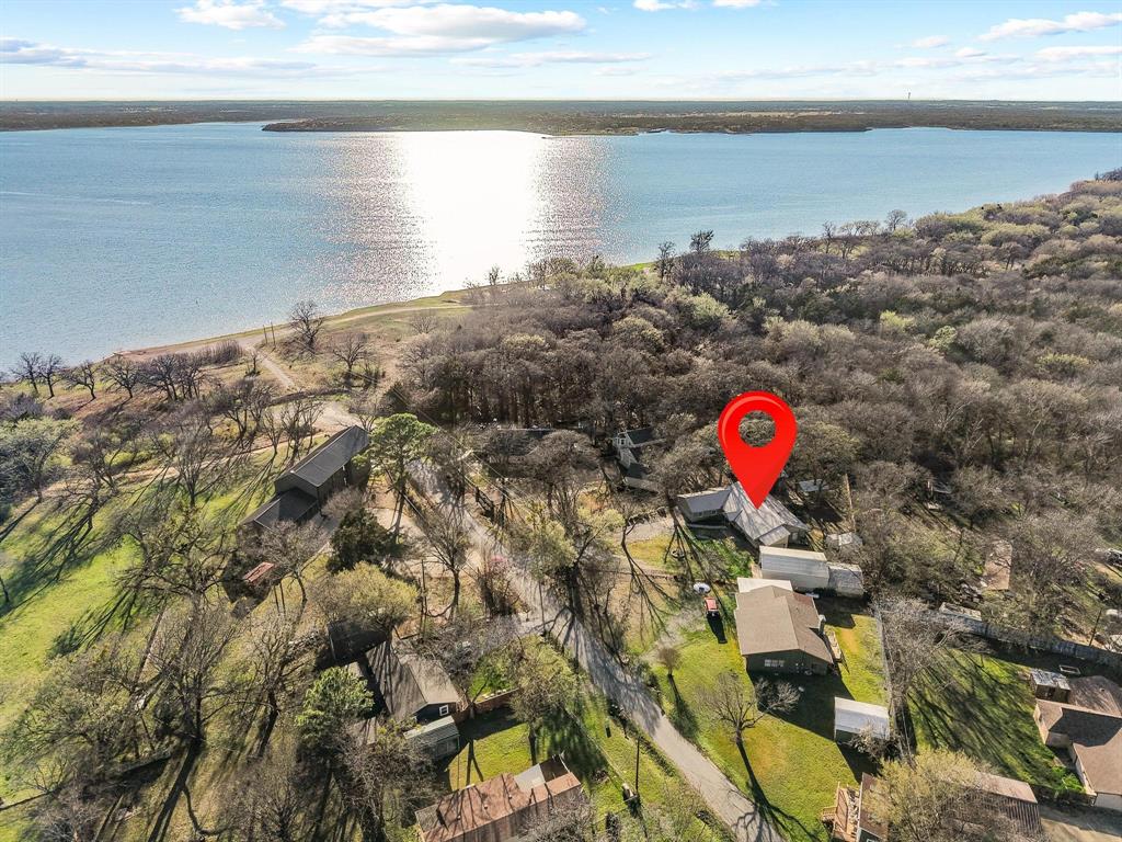 Lake Texoma Access • Guest house • RV and Boat Parking • Extra Large Detached Carport with Workshop • Scenic Trail to Neighborhood Beach

Lake property on a 0.50-acre lot at the end of a quiet, road in the Paradise Acres community near Lake Texoma. A short trail leads to neighborhood beach access. Appox 0.1 mi to beach trail • 5 mi to Mill Creek Marina • 6 mi to Flowing Wells Marina • Nearby multiple boat ramps. Property allows short-term rental use.

Main residence offers ~1,922 sq ft with 3 bedrooms, 2 bathrooms, two living areas, and sunroom. Interior features include granite countertops, waterproof laminate flooring, recessed & decorative lighting, ceiling fans, and propane fireplace. Open-concept floor plan provides flexible gathering space.

Separate ~570 sq ft guest house with 2 bedrooms, 1 bathroom, and its own water heater provides additional space for visitors or extended stays.

Outdoor amenities include covered back deck with hot tub, fire pit area, fenced yard, and lake views. Attached 2-car garage plus 22'x54' detached extra large carport accommodates RV, boat, additional vehicles and lake toys.

Don't miss your opportunity for living your best lake lifestyle at Lake Texoma as a primary residence or vacation home.