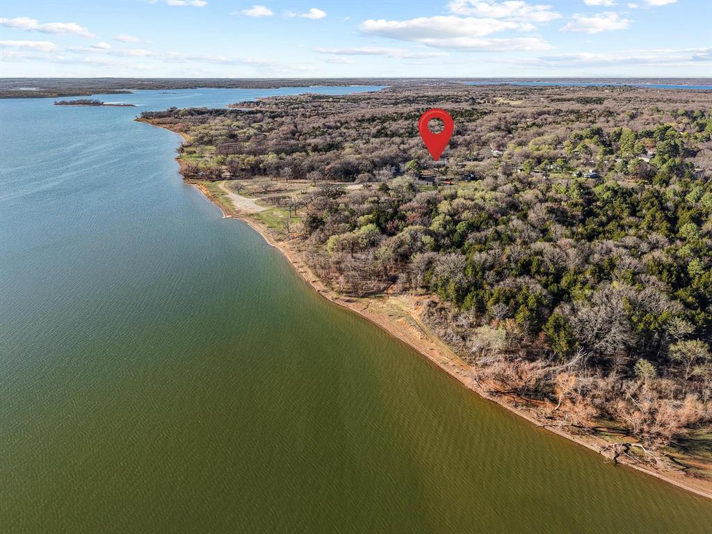 Lake Texoma Access • Guest house • RV and Boat Parking • Extra Large Detached Carport with Workshop • Scenic Trail to Neighborhood Beach

Lake property on a 0.50-acre lot at the end of a quiet, road in the Paradise Acres community near Lake Texoma. A short trail leads to neighborhood beach access. Appox 0.1 mi to beach trail • 5 mi to Mill Creek Marina • 6 mi to Flowing Wells Marina • Nearby multiple boat ramps. Property allows short-term rental use.

Main residence offers ~1,922 sq ft with 3 bedrooms, 2 bathrooms, two living areas, and sunroom. Interior features include granite countertops, waterproof laminate flooring, recessed & decorative lighting, ceiling fans, and propane fireplace. Open-concept floor plan provides flexible gathering space.

Separate ~570 sq ft guest house with 2 bedrooms, 1 bathroom, and its own water heater provides additional space for visitors or extended stays.

Outdoor amenities include covered back deck with hot tub, fire pit area, fenced yard, and lake views. Attached 2-car garage plus 22'x54' detached extra large carport accommodates RV, boat, additional vehicles and lake toys.

Don't miss your opportunity for living your best lake lifestyle at Lake Texoma as a primary residence or vacation home.