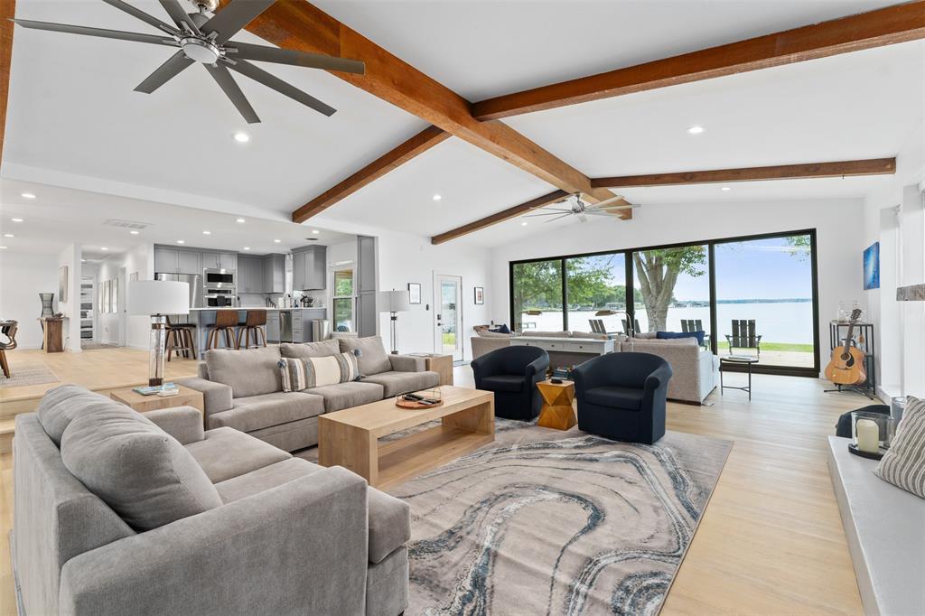 GB-9215. Perched on a rare peninsula point, this remarkable lakefront property offers more than 200 ft of private shoreline & outstanding water depth, with approximately 10 ft at the dock. From the moment you walk through the door, the home showcases sweeping views of wide-open water through an abundance of windows that fill the space with natural light. The thoughtfully designed open-concept layout features soaring vaulted ceilings accented by rustic wood beams, creating a warm yet spacious living area centered around a cozy WBFP. Large sliding doors open to the outdoor living space, making it easy to enjoy the lake lifestyle and entertain guests both inside and out. The kitchen is well-equipped with stainless steel appliances, including a double oven that’s perfect for hosting holidays or large gatherings. On the main level, the primary suite & an oversized guest suite both enjoy beautiful lake views and bright, airy surroundings. Upstairs, the home continues to impress with two bunk-style bedrooms and a full bath positioned above a generous game room that functions as a second living area. This upper level operates on its own HVAC zone for added comfort and efficiency. Extensive updates have been completed including the HVAC system, water heater, appliances, cabinetry, fixtures, and expansive use of glass—providing peace of mind for years to come. Outside, mature trees frame the shoreline while a lakeside fire pit offers the perfect place to relax and take in the scenery. With exceptional water depth (approximately 10 feet at full pool) and open, navigable waterfront, this property is ideal for boating and recreation. Short-term rentals are allowed, making it an excellent opportunity for personal enjoyment, investment potential, or both.