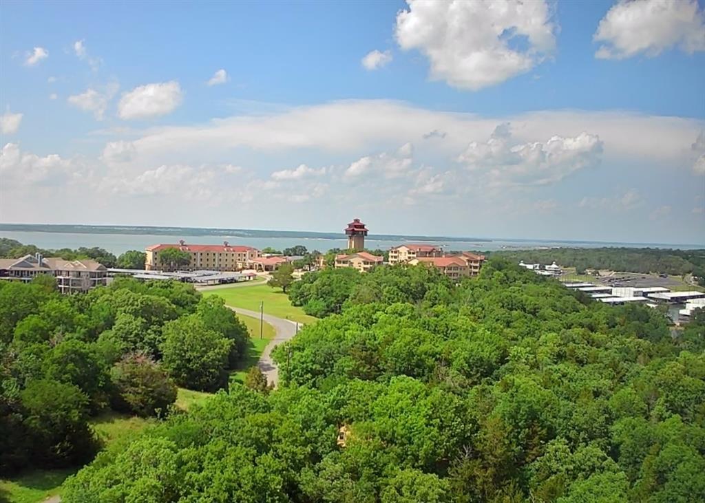 When it comes to buying a lot on Lake Texoma, it's all about location. And when it comes to location, this lot has it all. The gently sloping, heavily wooded, half acre plus lot sits in the very heart of Tanglewood.  In fact, the lot sits on the corner of Lakewood Ln and Idlewild Drive less than a block from Tanglewood Clubhouse and Hotel.  A seasonal creek with waterfall flows through bottom quarter of lot & large trees provide shade all summer.  This is one of the last truly great lots remaining in Tanglewood.
Highport Marina is a four-minute walk from the lot.  You can literally walk to your boat or to the Tanglewood pools or the Island Bar and Grill from the lot.  And this is a neighborhood Full of amenities: 3 outdoor pools, an indoor pool and hot tub, all with food service, Three Restaurants & two additional bars, one of which is in Tanglewood Tower with an unmatched view of Lake Texoma.  Pickleball courts, a play yard, Lodging and more, Plus, Tanglewood’s 18-Hole golf course and driving range are in the neighborhood, a short golf cart ride away.
Best of all, one of the most Beautiful recreational lakes in Texas is right here.  Lake Texoma with its miles of Sand Islands, Clean Water and Rocky Cliffs is great for boating, wakeboarding, skiing, water crafting, sailing, fishing and just playing in the water at the beach.  
The neighborhood is walking friendly, ATV and UTV friendly, kid friendly, comfortable and safe.  Come build your home or lake house where you can ride your golf cart or ATV to the pool or marina or golf course and your kids can ride their four-wheelers through the surrounding woods.  The over one-half acre lot can handle a 2200+ sq.ft. four-bedroom home with an onsite drip septic system, and has electric and water connections available at the street.
MAY at Tanglewood:  Memorial Day Weekend.  JUNE at Tanglewood:  Hosts Red River Bike Rally.  
JULY at Tanglewood:  4th of July Fireworks Extravaganza.  SEPT. at Tanglewood: Labor Day Weekend