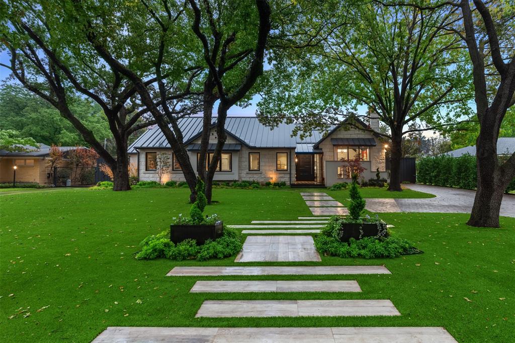 In coveted Preston Hollow, this Eco-Luxe masterpiece blends sustainability, wellness, and style. Crafted for simple, organic living, it features cathedral ceilings and expansive windows to seamlessly bring the beauty of the outdoors in. By day natural light fills the kitchen and living areas creating a bright, inviting atmosphere; by night, the home transforms into an entertainer's dream where the curated outdoor spaces glow and intermingle with the interior design. The kitchen's Onare cabinetry transforms everyday appliances into elegant furniture pieces and showcases high-end Gaggenau appliances known for sophisticated engineering and design. An adjacent dining room separated by a glass partition and a cozy breakfast nook offer dining options for every occasion. Thoughtfully designed, the layout effortlessly connects main living areas while maintaining distinct, functional spaces throughout. The first level primary suite overlooks the exquisitely landscaped pool, with an ensuite jewel box bath featuring floor-to-ceiling glass tiles illuminated by skylights. The main level also includes 2 additional bedrooms suites with adaptable closet systems, while a fourth bedroom offers versatility and can be utilized as a study, game or living area. The meticulously designed outdoor spaces extend the living areas with a fountain and dog-run on one side, while a state of the art OPHORA wellness pool plus an outdoor living and kitchen area with a wood-burning fireplace sits on the other side of the home. The turfed and xeriscaped front and backyards are just as low maintenance as they are beautiful! A Next-Gen-like suite with 2 bedrooms, a living area, kitchenette and a small flex space comprise the second floor with a balcony overlooking the pool. Features like the Savant smart home system, Ophora whole-home water filtration system, and advanced ERV and air filtration systems create a sanctuary of clean, modern luxury in this certified LEED Platinum property in Preston Hollow.