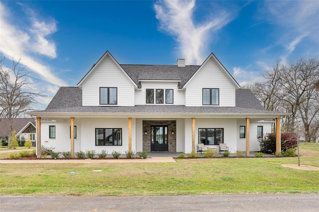 Lake Views from this gorgeous custom built, barely lived in home situated on three lots in one of the most desirable locations on Cedar Creek Lake. Located in the prestigious gated community of Enchanted Isle, this stunning property offers a truly unique setting, drive across the isle with water on both sides welcoming you home. An inviting front porch sets the tone as you enter this thoughtfully designed home featuring a spacious living area with a fireplace that flows seamlessly into a state-of-the-art chef’s kitchen. The kitchen showcases quartz countertops, a gas cooktop, a large island, and an incredible working pantry perfect for storage and entertaining. The first floor also features a large laundry room with a built in desk ideal for multitasking. A second living area filled with beautiful natural light offers lake views and is perfect for a reading room, office, or can easily be converted into an additional first-floor bedroom with a full bath nearby. The spacious primary suite is located on the first floor and includes a fabulous ensuite bath and large walk in closet. Upstairs you’ll find two additional bedrooms along with two oversized flex rooms that could easily serve as large bunk rooms, game rooms, or additional bedrooms. Storage is abundant throughout the home, including the oversized two-car garage. With no carpet anywhere, the home is both stylish and easy to maintain. Step outside and experience your own private resort. Situated across from the lake with beautiful lake views, the backyard features a stunning built-in pool with electric cover, heating capability, and a cooling system. A mosquito misting system allows for comfortable outdoor living while enjoying the covered patio or relaxing on the charming front porch. A community boat dock is just around the corner, giving you quick access to one of the best protected coves on Cedar Creek Lake perfect for boating, swimming, and floating right at your doorstep. A True Dream Home awaits.