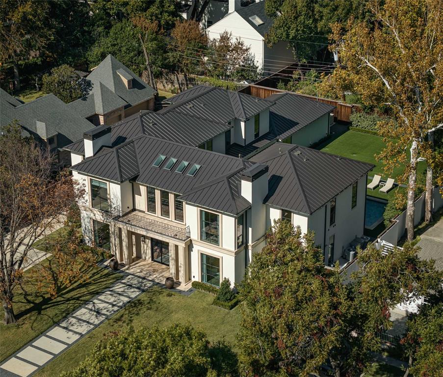 This Preston Hollow home boasts contemporary design with a floorplan perfect for entertaining. Completed in 2019, the 5-bed home has 6 full baths and 1 half bath and spans 6,944 sqft. The first level includes a porcelain-clad foyer with winding staircase, a formal living room, an open-concept family room-kitchen-breakfast nook, a dining room, and a mud room. In the kitchen find European cabinetry, Miele appliances, a waterfall island, and a walk-in pantry with a refrigerator. The first level’s bedroom, which can act as a secondary primary, features a modern bathroom with a rain shower and walk-in closet. On the second level, find 3 guest bedrooms with en suite baths and walk-in closets, a gym, and a primary featuring a magazine-worthy walk-in closet and a spa-like bathroom. The backyard features a new outdoor kitchen, a turfed yard, and a heated pool. Find exquisite details at every turn: Conrad custom drapes, smart home tech, and a 3-car garage. This beautiful property has it all.