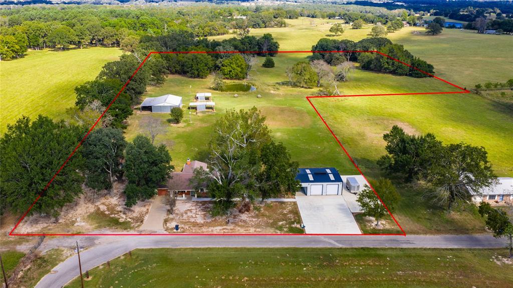 Beautiful countryside setting surrounded by large acreage tracts and impressive ranches. This updated home sits on 12 acres and offers two inviting living areas, one featuring a charming stone fireplace. The large country kitchen opens seamlessly to both living spaces, creating the perfect flow for family and friends to gather. The spacious primary suite captures peaceful countryside views and includes a luxurious bath with soaking tub, walk in shower, and an expansive closet. A 900 sq. ft. metal shop includes a 500 sq. ft. finished living area with a half bath - ideal as a bunk room, guest quarters, or entertainment space- overlooking a sparkling swimming pool.