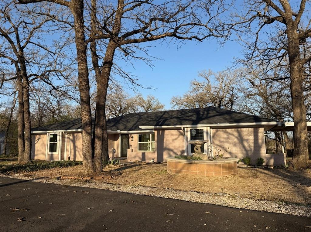 Completely remodeled in 2025 on nearly 1 acre - NO HOA!  Brand new Class 3 Impact-resistant roof, all new  windows, all new exterior and interior doors, and partial sewer line at back of house.  Every major system has been addressed so you can move in with confidence.  Engineered foundation with transferable lifetime warranty and french drain system for superior drainage protection.
Spacious 4 bedroom, 3 bath home with 2 master suites, each with private en-suite bath.  Separate office or study.  Open concept family room features vaulted ceilings, wood burning fireplace and designer ceiling fan.  Chef's kitchen with custom soft-close cabinets, quartz countertops, SS appliances, breakfast bar and a butler's pantry perfect as a coffee bar.  French doors open from the family room and primary bedroom onto a large deck overlooking the expansive yard.
LVP flooring throughout living and bedroom areas, porcelain tile in all wet areas, custom baseboards and trim.  All bathrooms fully remodeled with custom tiled showers and tubs, quartz counters, soft-close cabinetry, upgraded fixtures, and smart bidet toilets.  Dual HVAC zones for year round comfort.
Beyond the 2 car garage, enjoy a 2 car carport and circular driveway for additional parking.  Air conditioned 16X24 metal workshop - ideal for hobbies or a home business.  Two additional storage buildings in the backyard.
Nearly one acre of mature trees provides privacy and endless possibilities.
Mansfield ISD.  Minutes to 1-35W, shopping, and dining.  Country feel with city conveniences.