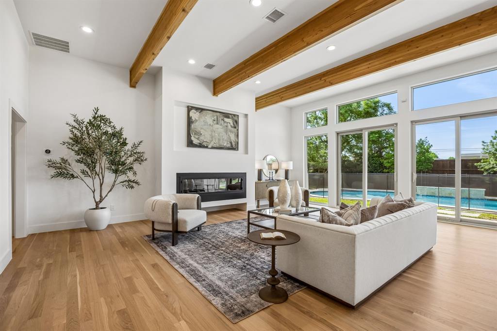 Tucked within one of North Dallas’ most sought-after communities in the private school corridor, this fully reimagined modern ranch blends elevated design, thoughtful functionality, and resort-style living on an oversized lot.
This home showcases newly installed white oak select hardwood flooring throughout, level 5 wall texture and curated designer lighting throughout. The reimagined floor plan offers both flexibility and flow, anchored by a stunning great room with raised ceilings, exposed beams, a dramatic wall of windows, and a sleek 72-inch linear gas fireplace.
Designed for both everyday living and entertaining, the kitchen is a true centerpiece with a quartz waterfall island and custom dining bar, Bertazzoni appliances, custom cabinetry, and designer finishes that seamlessly connect to the main living spaces.
The primary suite offers a private retreat with dual walk-in closets and a spa-inspired bath featuring marble and glass finishes, high-end fixtures, and elevated detailing throughout. A versatile fifth bedroom with en-suite bath provides flexibility for a guest suite, office, or additional living space.
Step outside to a backyard designed for both relaxation and entertaining. The pool and spa feature luxury glass tile, a triple waterfall feature, and modern lighting, creating a true resort-style experience. The expansive yard is framed by beautiful landscaping, freshly stained fence, and an electric gate for added convenience and security.
Beyond the aesthetics, the home offers peace of mind with extensive system improvements including new roof and gutters (2023), energy-efficient triple-pane windows, updated electrical, and a tankless water heater.
Ideally located just minutes from Dallas’ premier private schools, this home offers a rare opportunity to enjoy a turnkey, design-forward residence in a location known for long-term value and convenience.