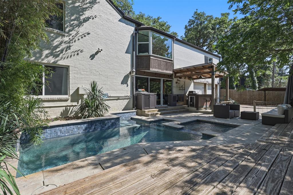 Welcome to your nature-escape treehouse home. This unique, timeless home, with interiors curated by Huehaus Atelier, is surrounded by sprawling mature trees, lush natural views, and a creek that runs through the property.

Nestled in an established Central Arlington neighborhood, this home offers the rare feeling of being wrapped in nature while still being close to town. The home features 5 rooms, including 4 bedrooms, with the 5th room currently used as a second primary bedroom, 3 bathrooms, and 2 large living rooms — one on each floor — both filled with natural sunlight.

The upstairs level features an open-concept living room with a chef’s kitchen, banquet breakfast nook, separate formal dining room, and an entertainment-worthy dry bar. A large laundry room with an upstairs laundry chute adds everyday convenience. Downstairs, the spacious game-room living area includes built-in bookshelves, creating the perfect setting for relaxing, gathering, or hosting.

Outside, the inground pool and covered outdoor kitchen make the backyard ideal for entertaining, staying cool in the Texas heat, or simply enjoying quality family time under the trees.

This charming gem offers the serenity of nature, the character of an established neighborhood, and the convenience of being just a short distance from AT&T Stadium, Globe Life Field, Texas Live!, and countless restaurants, bars, and shopping destinations.

Come make this treehouse home yours before it’s gone.