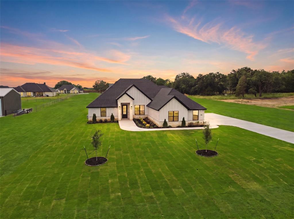 New construction by Al Couto Homes in the desirable Arbor Vista community of Azle, Texas, zoned to highly sought-after Springtown ISD. Situated on a spacious 1-acre lot, this modern farmhouse-style home offers a 3-car garage, dedicated home office, split-bedroom layout, and high-end finishes designed for both everyday living and entertaining.

Step inside to soaring ceilings, an open-concept floor plan, and durable wood-look tile flooring throughout the main living areas. The spacious living room showcases a tray ceiling and a stunning floor-to-ceiling shiplap fireplace, creating a warm and inviting focal point.

The chef-inspired kitchen features a Texas-sized island, quartz countertops, stainless steel appliances, custom cabinetry, walk-in pantry, and a bright dining area overlooking the backyard and outdoor living space.

The private primary suite offers a true retreat with a spa-like ensuite bath complete with dual vanities, oversized walk-in shower, freestanding soaking tub, and an impressive walk-in closet with built-in shelving and storage drawers.

The thoughtfully designed split-bedroom floor plan provides privacy for the four secondary bedrooms, accompanied by two full bathrooms on the opposite wing of the home. A dedicated front office with natural light creates the ideal work-from-home space.

Additional features include a spacious utility room with built-in cabinetry, finished 3-car garage with epoxy flooring, foam insulation, and a high-performance Trane HVAC system with heat pump for energy efficiency.

Enjoy Texas outdoor living on the oversized covered patio, already pre-wired for entertaining and relaxation. The expansive 1-acre lot offers endless possibilities for a future pool, workshop, outdoor kitchen, or custom backyard oasis.

No HOA. Low tax rate. No PID. No MUD. Conveniently located near Fort Worth with the peaceful feel of country living.