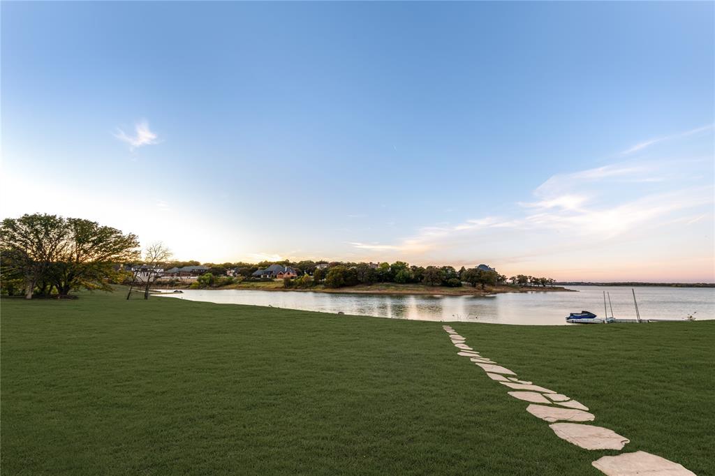 Waterfront and lake access in Highland Village! 1 of only 3 lake homes available in the area - 3111 Lake Creek Drive in The Pointe at Highland Shores, a truly exceptional waterfront custom home on one of the most coveted streets in Highland Village on the waters of Lake Lewisville. Not often do lake front homes, with this location & of this quality come to market, truly a rare opportunity!Brought down to the studs, a recently completed remodel done with unwavering attention to detail, this transitional classic home showcases luxurious finishes, meticulous design & unending style. From the moment you step inside, the home's stunning craftsmanship is immediately evident, a soaring glass wall - the entire home is bathed in natural light, sparing no expense with the custom sky bridge made for soaking in lake views, a grand gourmet kitchen with bespoke cabinets, a La Cornue range and plenty of spaces throughout that flow seamlessly for indoor-outdoor living. A dream for family gatherings and multigen enjoyment! Large study w custom built-ins & secret door leading to workout room, a wine cellar, poker lounge, glass enclosed cabana bar that opens up to an infinity pool, easy lake access & amazing sunsets on the water. Upstairs is 6 ensuite bedrooms as well as bunk room with locker-style bath, massive game room w large entertainment balcony overlooking the lake, a cozy library for tucking away the entire home was designed with intentional private areas for gathering in small groups and to provide cozy spaces to retreat to so everyone can enjoy having room without compromising comfort & peace! Feeding to Mcauliffe&Briarhill easy access to Liberty Christian in Argyle & no need to sacrifice shopping and other modern conveniences!Easy access to DFW airport! Close to Frisco as well. Enjoy the lakeside retreat living everyday with the freedom to install a floating dock to complete the best-of-both-worlds resort lifestyle living. Perfect legacy home in an unbeatable location!