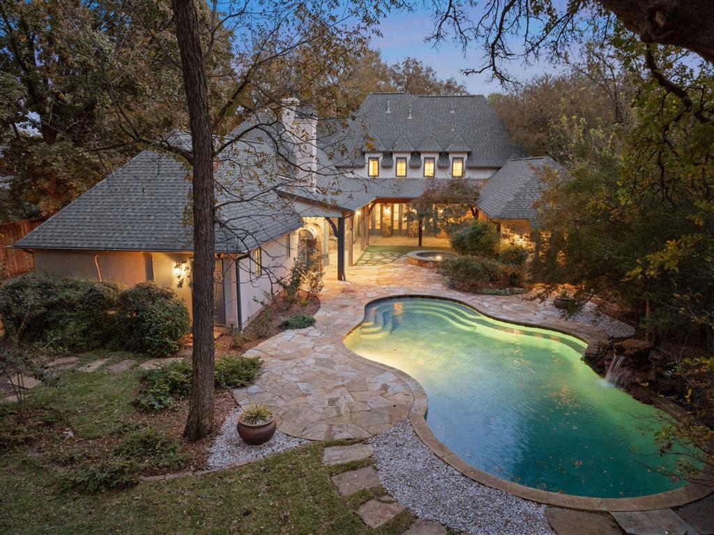 Nestled in the prestigious Forest Hills neighborhood and just steps from White Rock Lake, this elegant custom-built French Country estate property sits on nearly an acre. Behind its storybook exterior lies an inviting retreat designed for both everyday comfort and extraordinary entertaining. There are 5 bedrooms, 4.5 baths and a generous 3 car garage. The home features quality craftmanship with hand-scraped hardwood floors, French doors leading to a loggia, and high ceilings.

The first-floor primary suite serves as a private sanctuary, with a spa-inspired bath featuring antique brick floors, dual vanities, a soaking tub, and a steam shower. Off the great room find a hidden office, cleverly concealed behind a bookcase. The grand dining room is accessible through a walk through bar and opens to its own secluded courtyard, tucked away behind a stone wall. The first floor also features an additional guest suite and laundry room off the primary closet for convenience.

Upstairs, 3 generous sized bedrooms and 2 full baths are thoughtfully connected by both front and rear staircases, offering flexibility and function for family or guests. Outdoors, discover your private oasis: a sparkling resort pool and heated spa, surrounded by mature trees, anchoring an expansive backyard designed for leisure and gathering. The covered patio with retractable phantom screens transforms into a year-round retreat, complete with alfresco dining and lounging areas with a wood burning fire place.

Additional highlights include: new roof in 2022, Caitlin Wilson light fixtures throughout, a Generac generator, gated entry, 3 wood burning fireplaces, mosquito misting system and outdoor shower. One of the larger lots in coveted Forest Hills - with it’s mature trees, large lots, boulevards and proximity to White Rock Lake and under 15 minutes to downtown Dallas, this one is a must see.