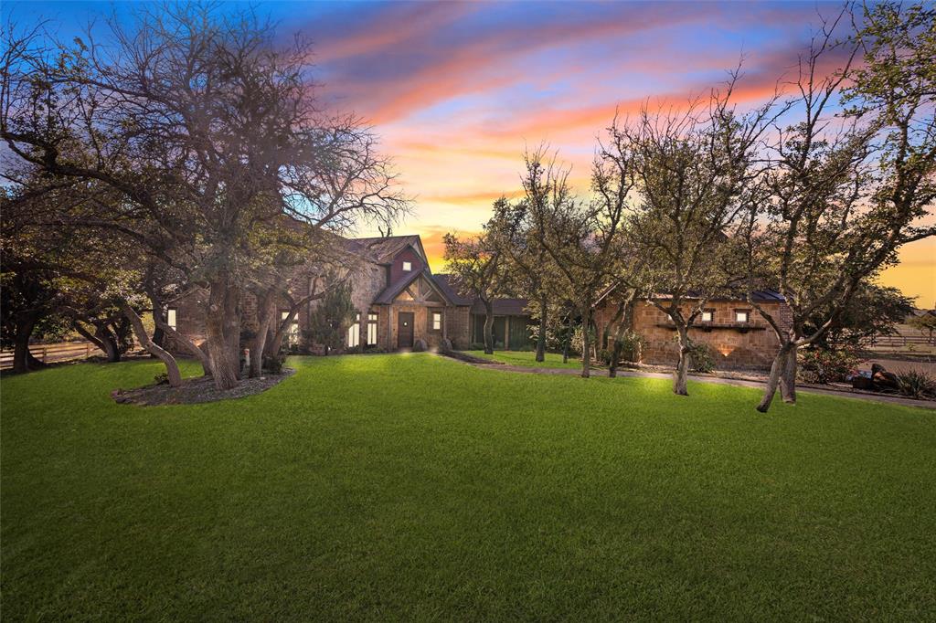 Welcome to a premier 30-acre Western estate where luxury and lifestyle come together seamlessly. Every detail is crafted for those who love the ranch life but appreciate refined comfort. The 4,406 sq ft main home offers four bedrooms, four baths, and warm, open living spaces that flow to a sparkling pool and outdoor retreat. A 1,354 sq ft guesthouse provides privacy for family, friends, or ranch staff. For the true horseman, enjoy a 100×170 climate-controlled indoor arena, a 125×225 lighted outdoor arena, and two barns with a total of ten stalls and automatic waterers. The smaller barn currently serves exotics but easily converts for horses. A 50×100 climate-controlled shop and 1,800 sq ft office make this property ideal for business and ranch operations. Set among mature trees with a one-acre stocked pond and approximately twenty acres of open pasture, this estate captures Western elegance at its finest — and with quick access to the Ric Williamson Bypass and downtown Weatherford, you’re never far from everything you need.