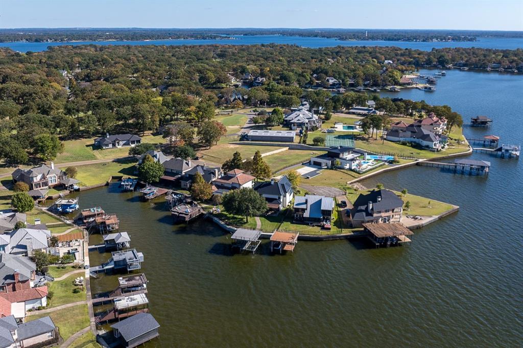 Updated Waterfront Home in The Pinnacle Golf Club, Cedar Creek Lake. This beautifully updated waterfront home offers excellent water depth, stunning views, and an ideal layout for both weekend getaways and full-time living highly sought after Pinnacle Golf Club community. Meticulously maintained, the home features high ceilings throughout the main level, a gourmet kitchen, and a downstairs primary suite, all designed to maximize the incredible lake views. The addition of a spacious outdoor living area and full outdoor kitchen creates the perfect setting for entertaining family and friends. Inside, a soaring staircase leads to three upstairs bedrooms plus a large bonus room, providing ample space for guests and multi-generational living. Storage is abundant throughout the home. The property is designed with families in mind, offering a fully fenced yard, beautiful landscaping, and the rare convenience of being within walking distance of the clubhouse. This exceptional home is built to be enjoyed for decades, a timeless lake retreat for your entire family. A social membership to Pinnacle is included, with a one time mandatory .002 of the sales price for a buyer transfer fee with the purchase of this property.
