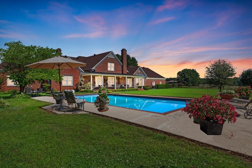 Nestled on one of the highest hilltops in Paris, Texas, this exceptional ranch spans 375 acres and features a meticulously crafted brick home. The property includes two barns, working pens with pipe fencing, and pristine pastures, perfect for maintaining livestock year-round. The land boasts large trees, multiple year-round stock tanks, and ample grass to sustain your livestock through winter. The spacious 5 to 6-bedroom home offers grand rooms with crown molding, elegant floors, and expansive porches both front and back, ideal for relaxation or entertaining. A large swimming pool enhances the home's appeal, making it perfect for a large family or hosting guests. For those seeking seclusion and a blend of luxury and functionality, this ranch is an unparalleled opportunity.