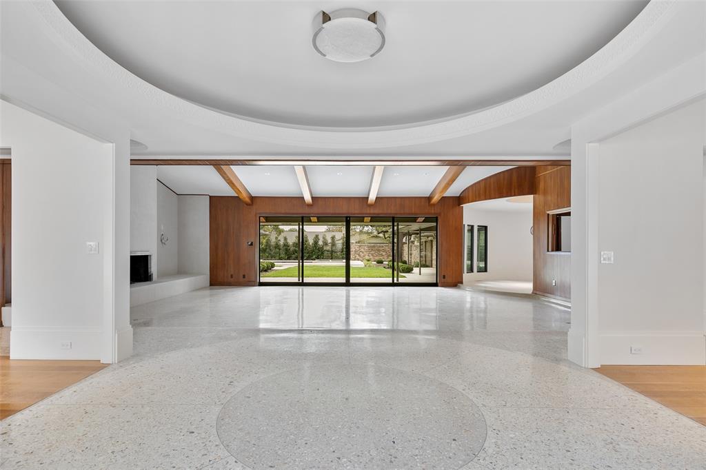 This sprawling 6,800 square foot mid-century modern home has been transformed by MORE Construction and Chad Dorsey Design.  Completely remodeled, but with plenty of original character, you will feel the connection from the moment you step through the new glass front doors, which open to a spectacular entertaining space.  The house remains true to its original elements centered upon a round kitchen, extravagant terrazzo floors, and an extensive prep kitchen and studio or office, but boasts modern luxury such as custom cabinetry, Kelly Wearstler lighting in the entry, and a bespoke STRIKE mantel.  The studio and prep kitchen enjoy a separate entry allowing the space to double as an in-law suite.  The primary suite, complete with his-and-hers closets, opens to a relaxing new pool, connected patios and extensive backyard landscaping.  Custom lighting, custom hardware and unique design elements throughout this home truly make it one-of-a-kind.