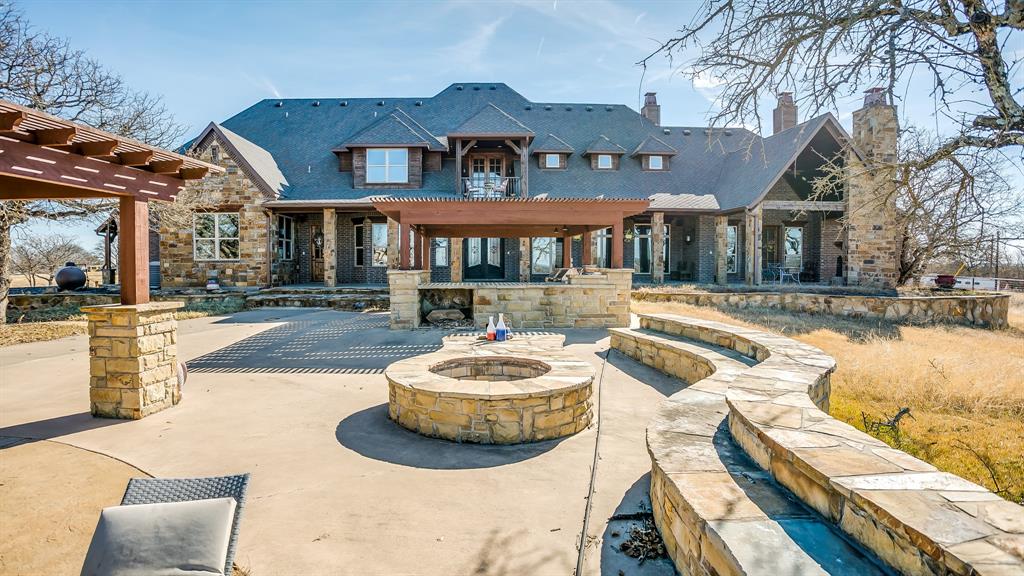 This custom masterpiece is your private oasis outside of the city limits in Brock ISD! Brilliant design features include climate-controlled bedrooms, indoor and outdoor entertainment areas galore including 2 living, 2 media,2 dining, 2 laundry, office, and gourmet kitchen with 2 built in sub-zero refrigerators, commercial grade gas range and sonic ice maker, as well as outdoor kitchen, balconies and a private fireplace directly off of the master suite! Detached workshop is 95x50 with 3 bays and a 1000sf garage apt., 27 fenced acres of pastures, trees and ponds ideal for your horses and livestock to roam! Resort Pool, Firepit and Pool House nestled under a canopy tree are only a few of the exquisite features!