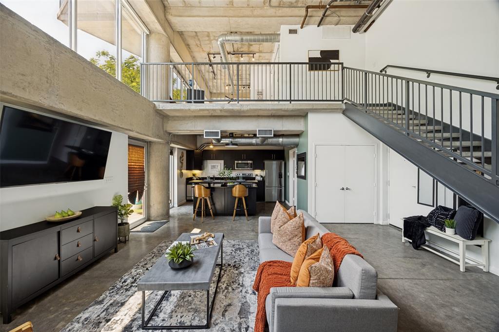 Stunning industrial loft-style condo nestled in vibrant Cedars District of Dallas. Perfectly positioned to offer exhilarating urban environment & lock-and-leave lifestyle, this condo combines modern living with a unique vibe that will excite! Step inside & be mesmerized by the soaring ceilings, allowing natural light to flood the space through an impressive wall of windows with automatic shades. Effortlessly control the ambiance, whether you’re basking in sunlight during the day or enjoying city views at twilight on the pool deck or your own private deck. Open-concept design flows effortlessly, making it ideal for entertaining. The well-appointed kitchen is functional yet stylish. The convenience of having 2 bathrooms adds privacy & comfort for you & guests. Stepping outside, you’ll find a private patio—perfect for morning coffee or evening chats under the stars. Not to mention, direct access to the dog run right across from your front door creates a haven for your furry companions. As a resident, you’ll have access to a host of amenities that promise relaxation & entertainment. Bask in the sun by the sparkling pool, unwind in the hot tub, or gather around the fire pit with friends. The lounge area offers opportunities for weekend barbecues & summer cookouts with friends & neighbors. Security is paramount, with a gated parking garage ensuring peace of mind. The bonus? Your assigned spaces provide convenient direct access to your front door, making coming & going a breeze. Living in the Cedars District means embracing a culture rich with live music venues, trendy bars, & captivating art galleries—all just steps from your new home. The striking skyline views of Downtown Dallas serve as the backdrop to your everyday life, adding an element of excitement & inspiration. This cool condo combines extraordinary features with urban living, making it an ideal choice for those who crave a lifestyle filled with adventure & comfort.