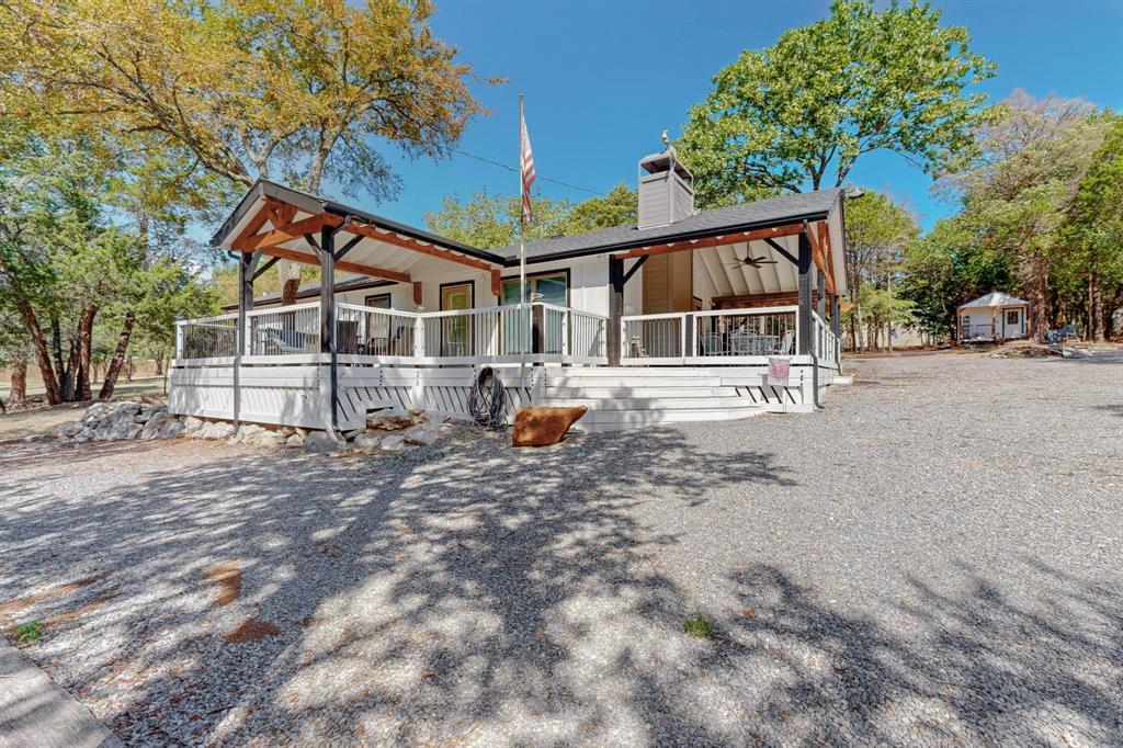 Lake Texoma Getaway!  This home has been updated and renovated with added front and side covered porches, back concrete and wood decks for incredible outdoor entertaining.  Circle drive, with home sitting on 1.26 acres.  Wooded lot, aggregate drive, and excess parking for boats and RVs. 
Renovated baths, and kitchen with updated appliances.  Views of the property from every room. New pitched composition roof and new covered porch architecture. HVAC in main house, updated to an all electric central system, with a mini split in the guest house.  The storage building at front of the property has a window unit in place and can be used as a workshop. Home has 2 hot water heaters. The guest house is 12X20 with a covered front porch and plenty of space to accomodate a bunk room for extra sleeping arrangements. Guest house has a built in desk for detached office area if you choose. Plenty of room to set up as an additional living space.  Come see this Jewel in the Woods of Lake Texoma.