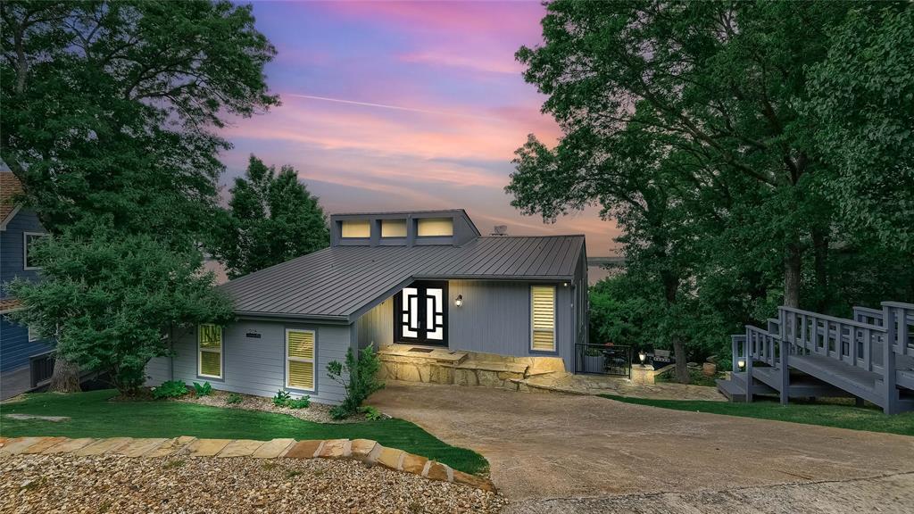 Imagine waking up to breathtaking panoramic views of Lake Texoma—sunsets that leave you speechless. Welcome to 218 Island View Drive, a lakeview retreat designed to showcase the beauty of the water from every angle.

This thoughtfully crafted home was built with the lake lifestyle in mind. Enter on the main level where you'll find an open-concept living room and chef’s kitchen featuring quartz countertops, a center island with an electric cooktop, double ovens, and a beverage fridge—perfect for entertaining.

A stunning stone see-through fireplace connects the living room to the spacious main bedroom, creating a cozy, elegant ambiance. The primary bathroom offers a spa-like experience with its oversized walk-in shower and luxurious soaker tub.

Downstairs, the first level includes a generous second living area with a wet bar, two additional bedrooms, and a full bath—ideal for guests or multi-generational living. Step outside to the backyard oasis with a flagstone patio, ideal for evenings under the stars.

Located just minutes from Highport Marina, and with a neighborhood boat ramp just down the hill, this is lake living at its finest.

Bonus: Ask about the assumable 2.625% mortgage! Don’t miss your chance to own this one-of-a-kind lakeview property—schedule your private showing today!