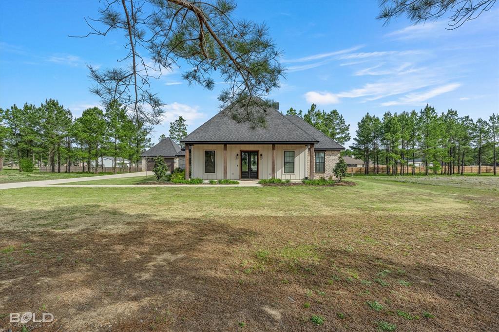 Situated on a full acre, this beautifully designed home offers the perfect blend of modern style, functionality, and space all in a quiet setting. Built just two years ago, every detail still feels fresh, current, and move-in ready.
From the moment you arrive, the welcoming front porch with rich wood accents sets the tone for the quality throughout. Inside, the open concept layout features soaring ceilings with exposed beams, abundant natural light, and a stunning brick fireplace that anchors the living space.
The kitchen is a true standout, showcasing a large quartz waterfall island, stainless steel appliances, custom cabinetry, and designer lighting ideal for both everyday living and entertaining. The seamless flow into the dining and living areas makes this home feel spacious yet comfortable.
The primary suite offers a relaxing retreat with a spa-like bathroom, including a freestanding soaking tub, double vanities, and a custom walk-in shower with dual rain heads and striking tile work.
Step outside to enjoy the covered back patio complete with an outdoor kitchen which is perfect for hosting or unwinding while overlooking your expansive one-acre lot.
Additional highlights include aer additional two car  detached garage setup with extended driveway.  Perfect place to storage all your toys.  Bonus room can be used as a flex space such as an office, play room, additional living or even a fourth bedroom. 
This is a rare opportunity to own a nearly new home with land, style, and functionality already in place. Come take a look and make this home yours today!
