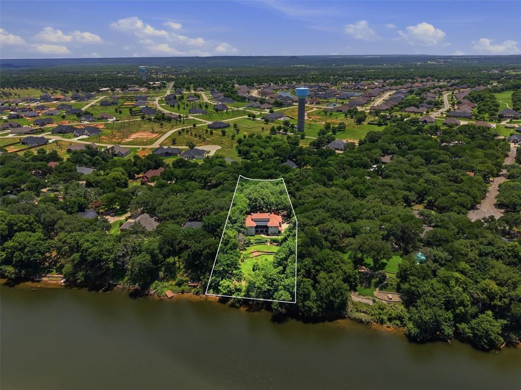 Welcome to a place where every day feels like a getaway. Nestled along the scenic Brazos River, this extraordinary waterfront retreat offers a rare combination of privacy, timeless craftsmanship, and an unmatched lifestyle. Wake up to peaceful river views, spend your afternoons fishing, kayaking, or boating from your own backyard, and end the day relaxing as the sun sets over the water.  Thoughtfully reimagined while preserving its unique character, the home blends historic charm with modern luxury. Warm reclaimed hardwood floors, striking exposed beams, and artisan finishes create an inviting atmosphere that feels both refined and comfortable. With two separate living areas, the home is perfectly suited for multi-generational living, extended family, long-term guests, or those seeking flexible spaces for entertaining, working from home, or creating private retreats under one roof.  Beyond the home, you'll discover a community built around recreation and connection. Enjoy the security and peace of mind of a gated neighborhood with access to multiple championship golf courses, nearby private airparks for aviation enthusiasts, and countless opportunities to embrace the outdoor lifestyle that makes this area so desirable. Whether your perfect day includes a round of golf, a flight from a nearby airstrip, or an afternoon on the river, everything is within reach. Properties that offer this level of waterfront living, flexibility, and community amenities are exceptionally rare—especially at this price point. Offering luxury, privacy, and an unparalleled lifestyle for under 1 million, this is more than a home—it's a legacy property where generations can gather, memories can be made, and every day feels like a vacation.