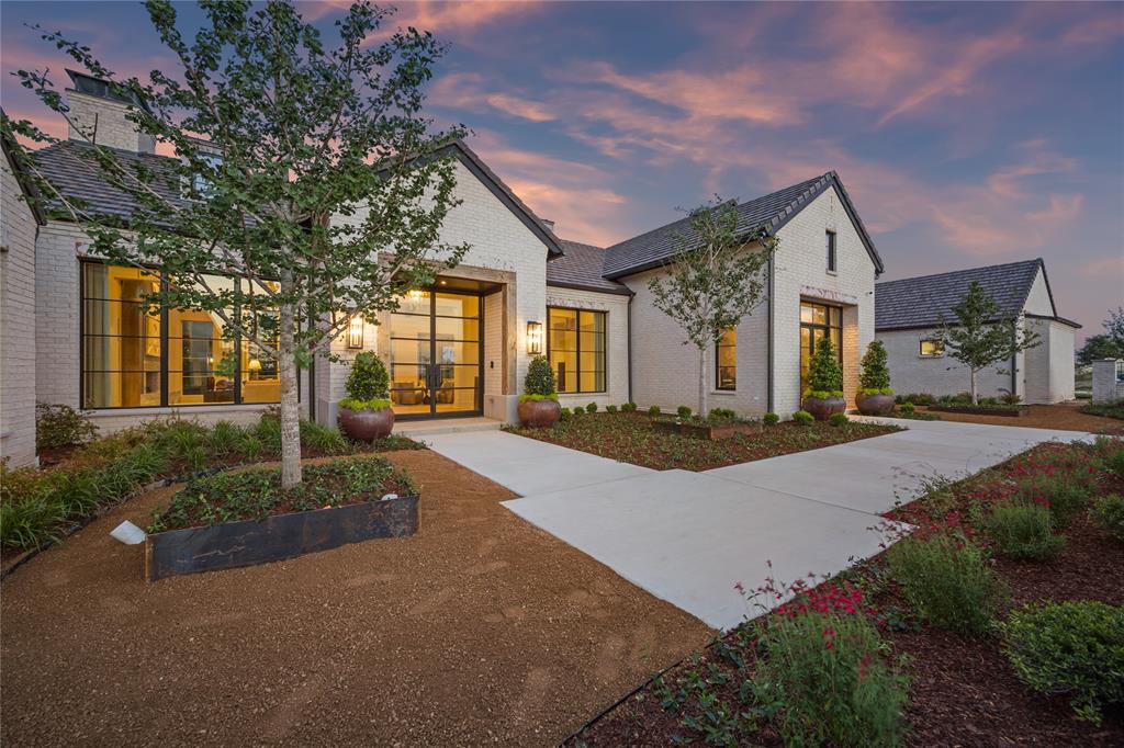 Perched atop a scenic hill in Fort Worth’s prestigious Montrachet neighborhood, this stunning single-story residence draws inspiration from the rustic elegance of Napa Valley. Designed to capture panoramic views of downtown Fort Worth, the home seamlessly blends refined architectural elements with natural textures and warm, vineyard-inspired tones.

Spanning a thoughtfully designed layout, the home features 4 bedrooms, 4 full and 2 half bathrooms, and a 3-car garage with additional motor court parking. The primary suite offers a true retreat with its own private patio, sitting area, dual closets, a safe room, separate vanities, a freestanding tub and walk-in shower, coffee bar, and a connected laundry room. Each of the three additional bedrooms includes ensuite baths and custom walk-in closets.

Designed for effortless living and entertaining, the open-concept living room flows into the dining area and chef’s kitchen—complete with a central island, a spacious back kitchen, and a separate walk-in pantry. The great room features a stylish wet bar, while a dedicated study offers a quiet space to work or unwind. A separate lounge with its own wet bar opens directly to the back patio, creating seamless indoor-outdoor living.

Outside, the amenities continue with a fully equipped outdoor kitchen, covered living area, and a sparkling pool—all framed by sweeping skyline views.

Architectural details include rustic stonework and distressed wood accents with a modern twist. The home’s clean exterior lines, metal accents, and limewashed finishes lend a timeless character, while the interior embraces soft greens, earth tones, and vineyard-themed color palettes—chardonnay, merlot, and cognac—infusing every space with a sense of warmth and lived-in luxury.