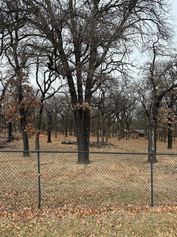 Rare, heavily treed, with a pond, and just over an acre in the heart of Azle.  The space would make a beautiful homesite with room for a shop and pool. Platted, waiting final approval from the City. Septic, water, electric and driveway will need to be installed. Close to the Park, lake, shopping and schools with an easy commute to Fort Worth, Weatherford and Alliance area. Pictures Coming Soon!