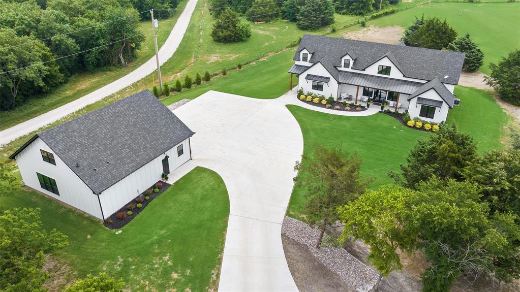 STUNNING CUSTOM RANCH ESTATE NESTLED ON 16.3 ACS IN THE COUNTRY! THE DRIVE UP IS TO DIE FOR. JUST OVER A YEAR OLD - SO IT'S BETTER THAN NEW, IT'S MOVE-IN READY - EVERYTHING YOU NEED IS ALREADY THERE. 3 SEPARATE LIVING QTRS. TOTAL 6349 SF+. NO HOA. IN THE COUNTY. PRIVATE POND with views of the creek & heavily trees. Enjoy the widelife as they graze in the pasture. Bring your horses or other animals, build a garden. THIS LUXURIOUS OPEN-CONCEPT HOME OFFERS SEVERAL TOUCHES OF CLASSY LIVING. GALLERY KITCHEN WITH COMMERCIAL APPLIANCE W.GAS STOVE, GIANT ISLAND WITH SEATING, EVERYTHING IS LITERALLY XL. Views everywhere you look. Breakfast room is precious. Back patio has dinning, living, & BBQ area with sink. Vaulted PRIMARY SUITE, such glamour is a dream. With his and her's separate walk-in custom closests, separate vanities, & separate shower & tub. The living room is really a GRAND-ROOM with equisite views a charming fireplace. Every bedroom is an ON-SUITE with walk-in closets. Upstairs offers a landing, bonusroom, XL Media-room connecting to full bath, & 4th On-suite BR with walk-in closet. 3 car garage with epoxy floors. 2nd living qtrs is connected to garage, it offers a full kitchen, all appliances, open concept living-room & BR, includes a full bathroom, walk-in closet with full size W.D. 50X60 Custom Muller BARN equipped with 3 rollup doors, plenty of shelves, upstairs storage loft, & additional concrete all around the barnquipment or adding on. 3rd living qtrs found in barn for ranch-hand or others. Full BR, kitchen space with frig, bathroom, & laundry. This sprawling adorable property offers many possiblities for your country dream in TEXAS.