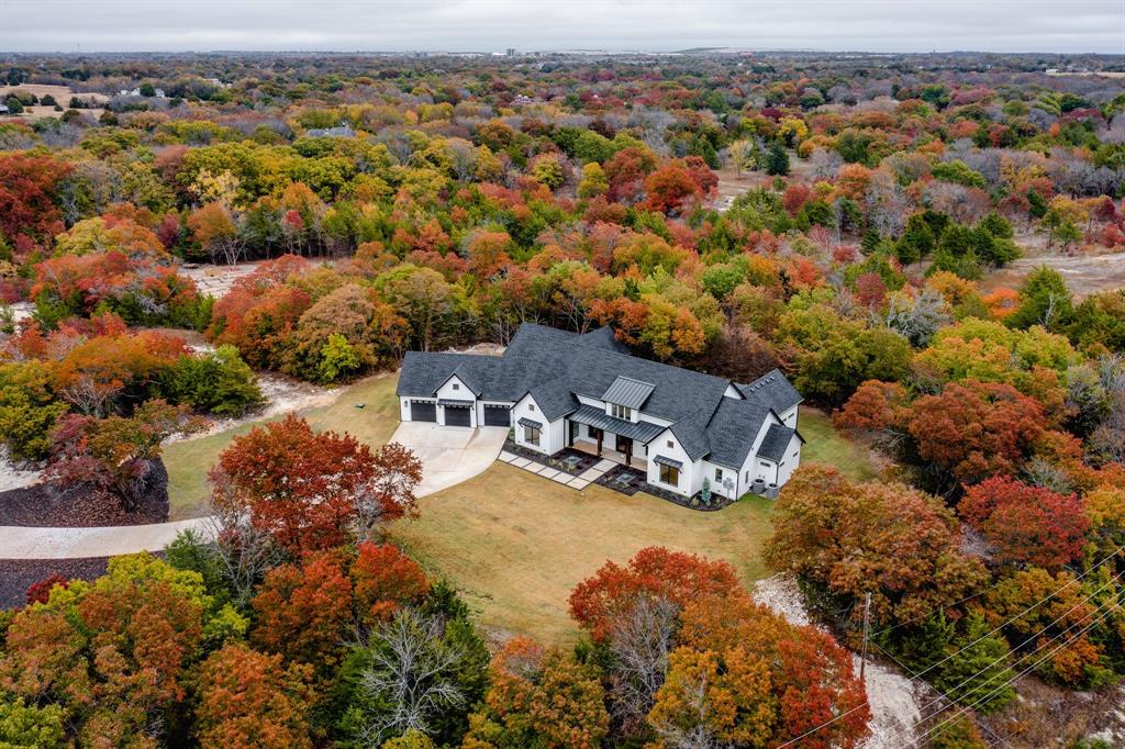 COMPLETED DECEMBER 2023. You will not believe you are in the Dallas area when you see this lot.  Very hilly, treed, secluded and private.  No HOA or City Taxes.  McKinney ETJ but not in the city limits. Melissa Schools close by. Fantastic one-story plan, with owner's suite private to other bedrooms. Tall ceilings throughout, with large bedrooms and bathrooms. Covered outdoor living area is usable 100% of the time as it has its own air-conditioning and heating system. Leave the (3) 15' wide doors open during great weather or keep them closed when it's not. No carpet in this house. Wood nail down flooring with large, oversized tiles adorn this house. Two story ceilings run the entire width of the kitchen, dining, and family room, with numerous chandeliers and decorative beam. Pass through window from the kitchen to indoor patio area. This house is what you have been looking for!