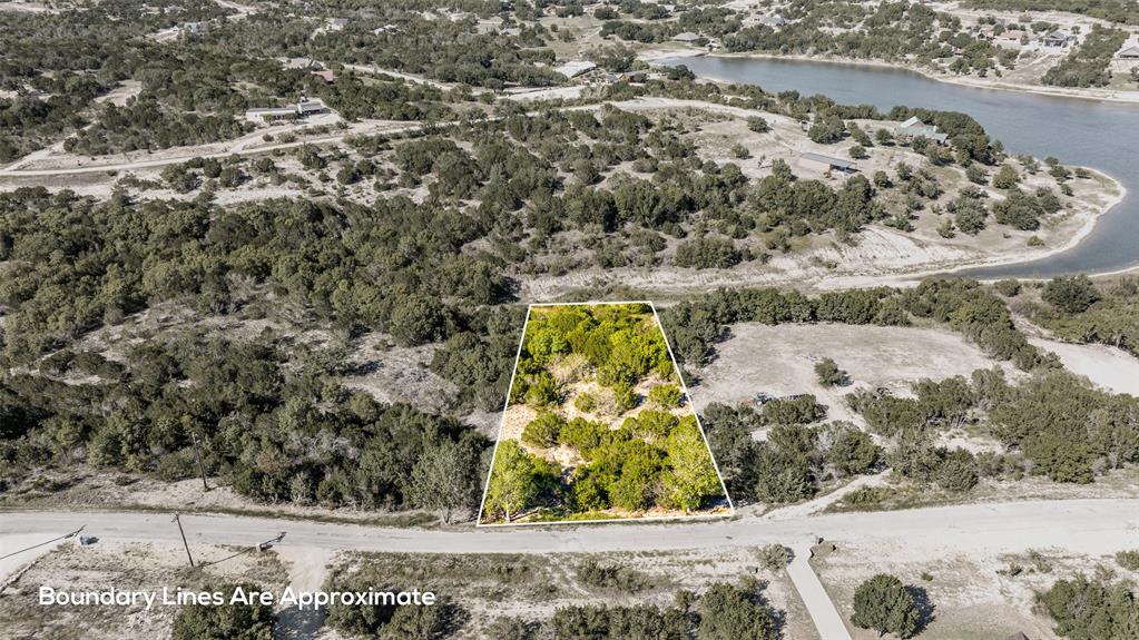 Neat 1 acre surveyed lot with seasonal creek that flows into Beacon Lake. Nice building spot in the middle. Soft and hardwoods scattered throughout.  Water and electric located at the front of the lot. No build time. 295.00 yearly assessment. 1400 square foot minimum living space. Bluff Dale is located on HWY 377 between the 'Cowboy Capital of the World', Stephenville TX and the Historical Granbury TX. Come and enjoy BEAUTIFUL Texas sunsets, star filled skies and abundant wildlife. Mountain Lakes offers a recreational lake, fishing lake, clubhouse, pool, park, walking path, garden and RV park. Country living at its finest