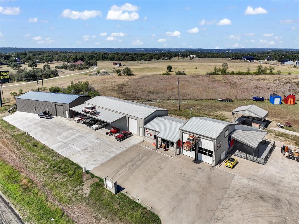 A classic car enthusiasts dream!  Two huge climate controlled storage facilities, 5000 sq ft and 4000 sq ft with office spaces, overhead doors, restrooms, maintenance materials storage in each building designed for display, maintenance and storage of classic vehicles, exterior covered carports for display, concrete parking galore. Third freestanding building is hospitality suite with kitchen, dining area, conversation and reception area, full bar area, restrooms, outdoor dining and dancing or gathering area, separate covered band stand. This property is turn key and ready for occupation by new owner or investor.  Seller would leaseback restaurant and one building long-term. There is an additional 2 acre parking area added on adjacent property with graded and paved road. This area would park approximately 300 cars. There is also a brick home on this additional 2 acres that is currently rented on a month to month basis for $1600.00 per month. Tenants want to stay but if new owner wishes to use home for other purposes it would make ideal separate office space or home for on-site property manager. the increase in price includes this additional 2 acres, improvements and rental home. No photos available of rental home. There have been numerous other improvements made to this property since photos were taken.  This property would make an ideal multiple use Event Center. Already has several Classic Car Shows scheduled for 2026    
Possibilities for use is enumerable.See all aerial and interior photos