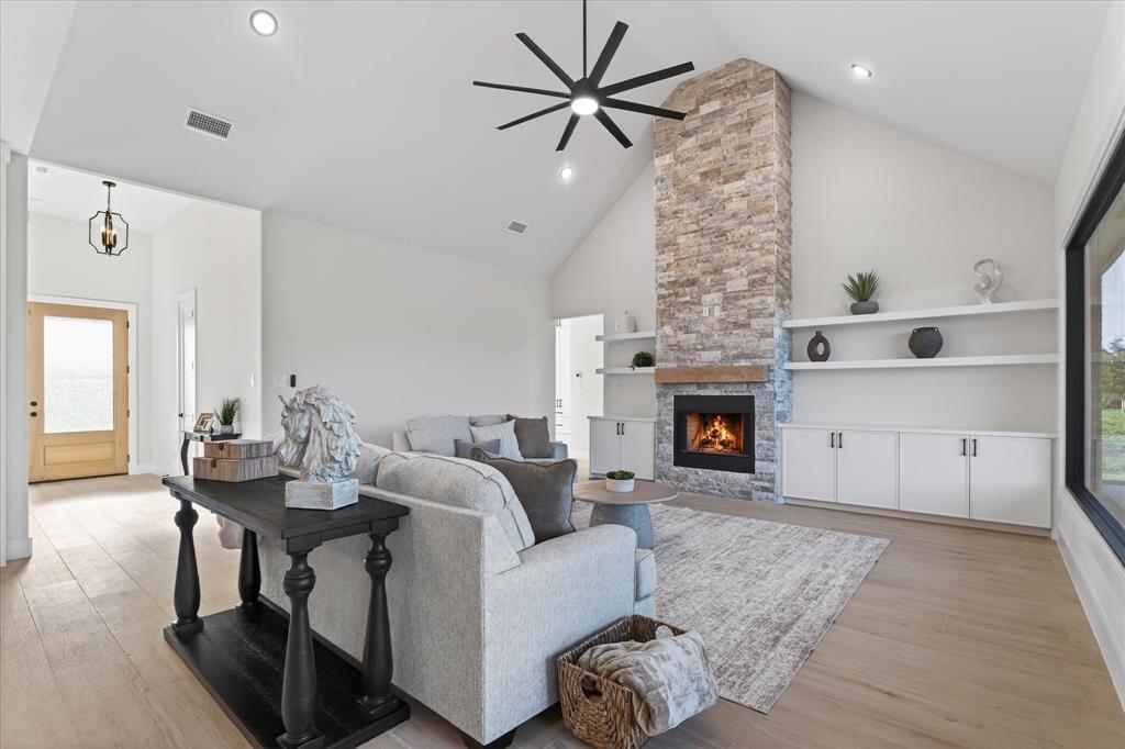 Experience elevated living in this stunning new construction custom-built home offering over 2,800 square feet of beautifully designed space set on more than an acre of land surrounded by mature trees. Designed with both elegance and functionality in mind, this home features four oversized bedrooms and a modern open-concept floor plan that seamlessly blends sophistication with comfort. Dramatic oversized windows flood the home with natural light and showcase peaceful views of the tree-lined property. The expansive living area is anchored by dramatic cathedral ceilings, a sleek modern fireplace, and floating shelves, creating a warm yet contemporary gathering space. Rich wood floors flow throughout the main living areas, perfectly complementing the home’s stylish design. The chef-inspired kitchen is equipped with stainless steel appliances, generous workspace, and modern finishes that make both everyday living and entertaining effortless. Retreat to the show-stopping primary suite, where the spa-inspired bathroom truly steals the spotlight. Indulge in the luxurious freestanding soaking tub, surrounded by the latest in designer tile work, along with dual vanities, a relaxing sitting area, and an oversized walk-in closet that will impress even the most discerning homeowner. Set against a serene backdrop of towering trees on an acre-plus homesite, this property offers the perfect balance of privacy, modern luxury, and space to breathe. With breathtaking design, soaring ceilings, and exceptional craftsmanship throughout, this custom home truly has it all.